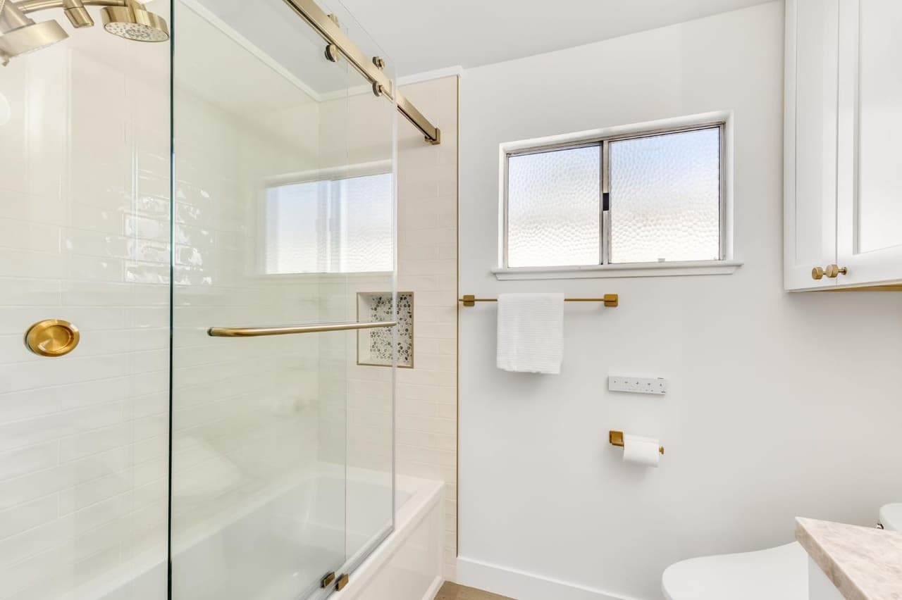 House Renovation in Davis — frameless glass shower, tiled shower surround, subway tile backsplash, tub-to-shower conversion, rain shower head