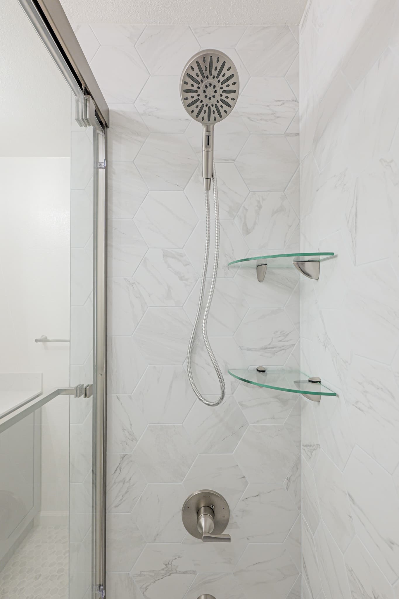 House Renovation in Sacramento — tiled shower surround, handheld shower, frameless glass shower, walk-in shower, marble tile flooring