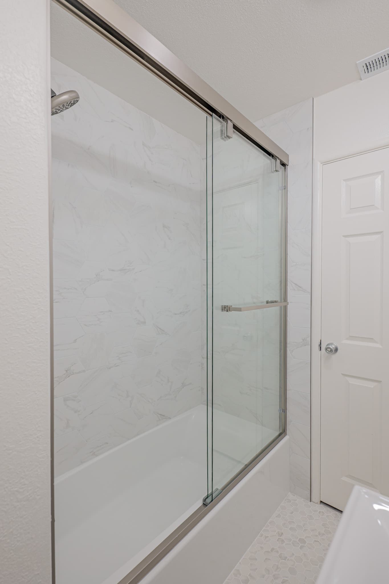 House Renovation in Sacramento — frameless glass shower, tiled shower surround, rain shower head, shower bench, mosaic backsplash