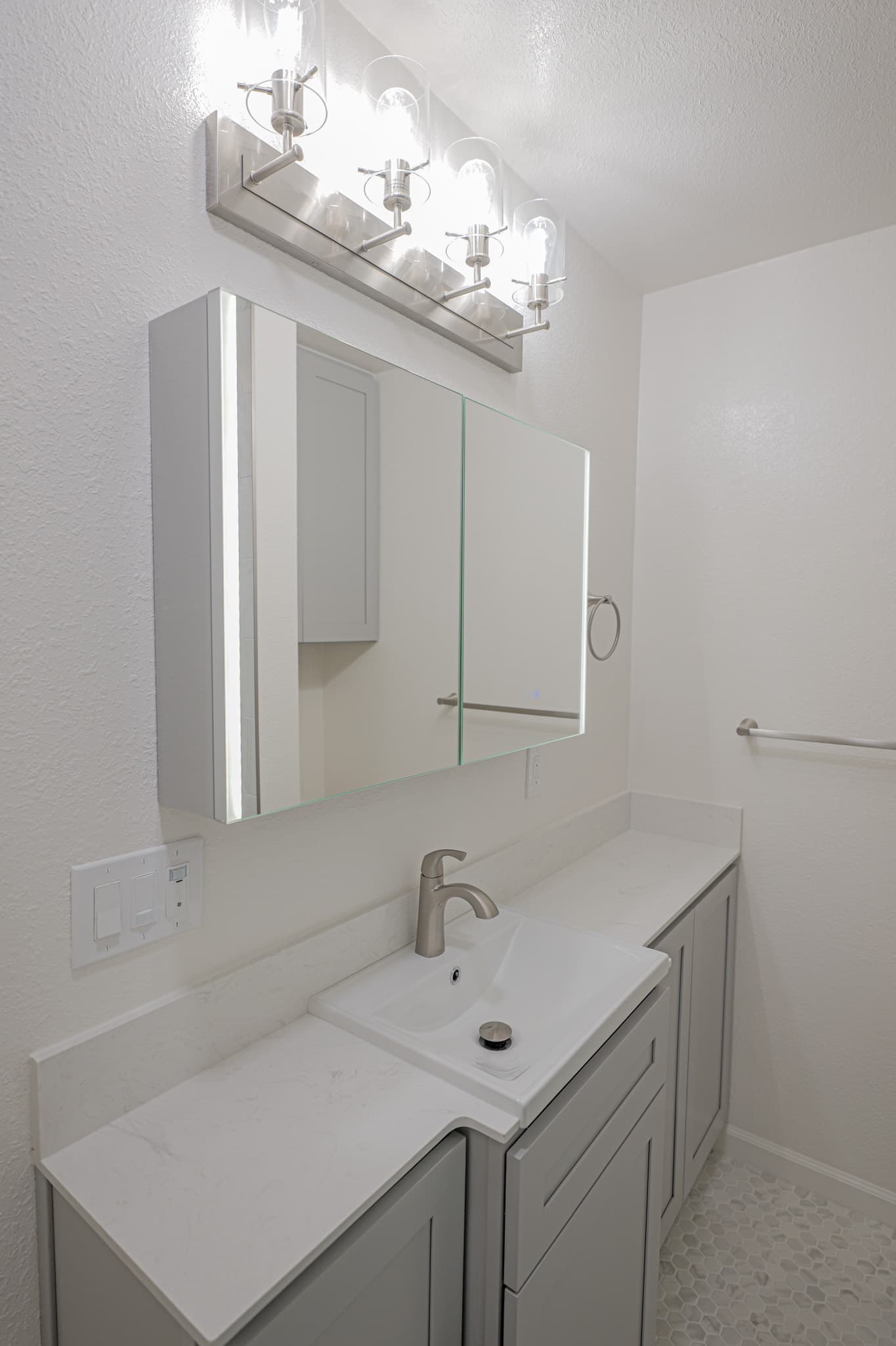 House Renovation in Sacramento — single vanity, shaker cabinets, quartz countertop, lighted mirror, mosaic backsplash