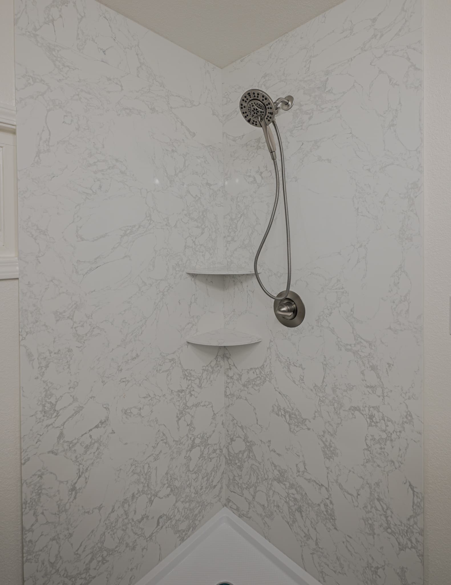 House Renovation in Sacramento — walk-in shower, tiled shower surround, handheld shower, marble tile flooring, built-in shelving