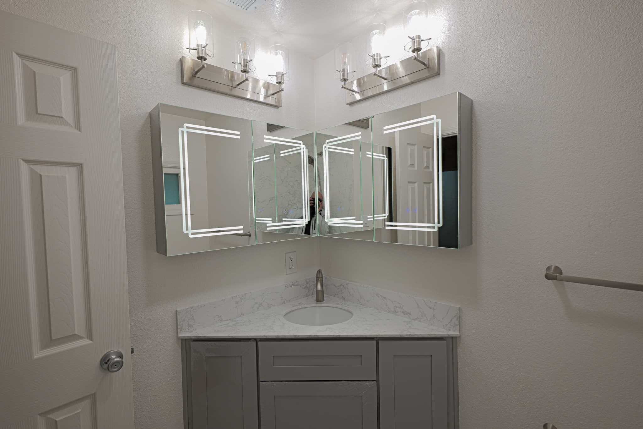 House Renovation in Sacramento — single vanity, lighted mirror, undermount sink, marble countertop, shaker cabinets