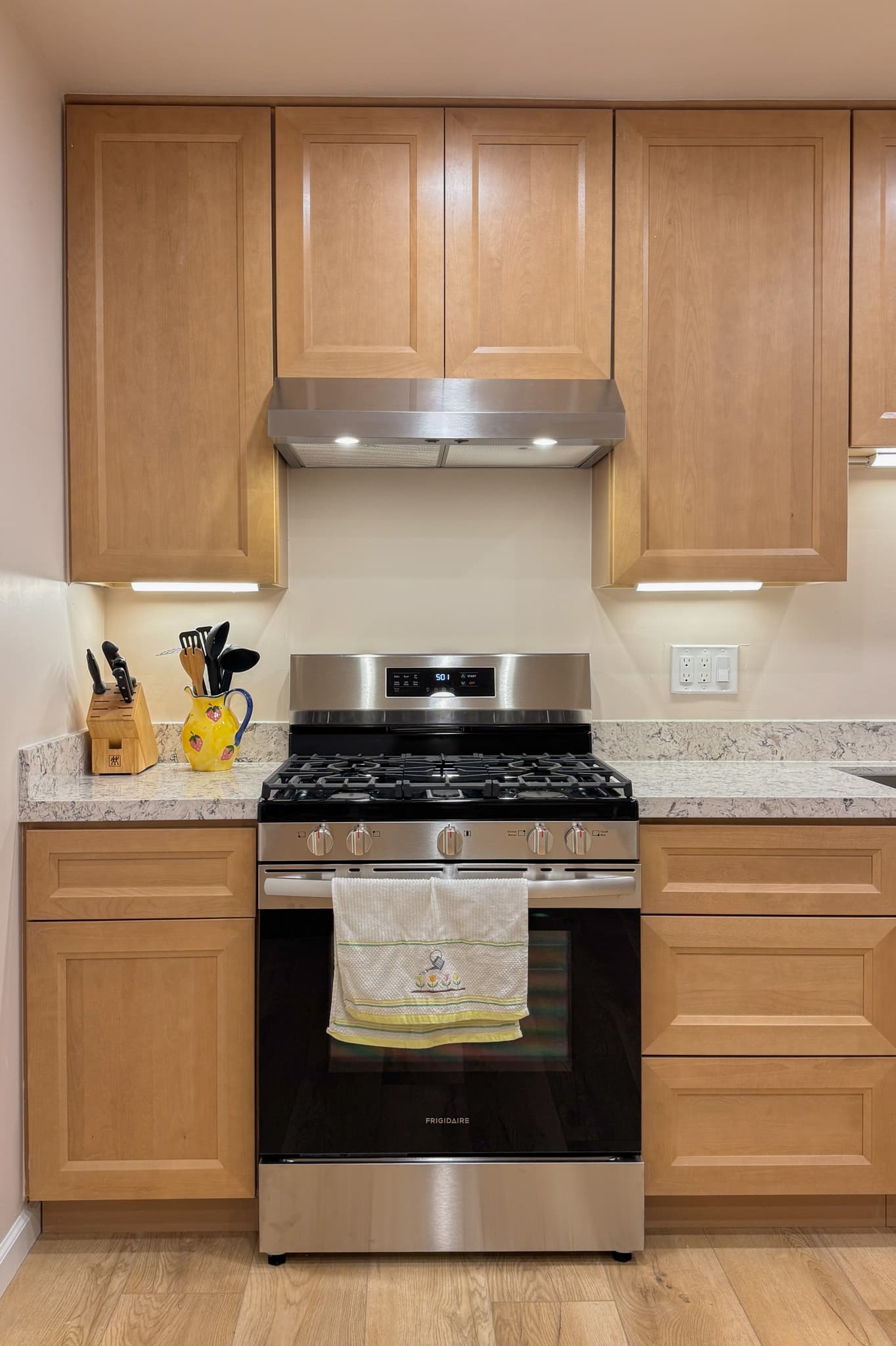 Kitchen Remodel in Sacramento — raised-panel cabinets, range hood, stainless appliances, quartz countertop, under-cabinet lighting