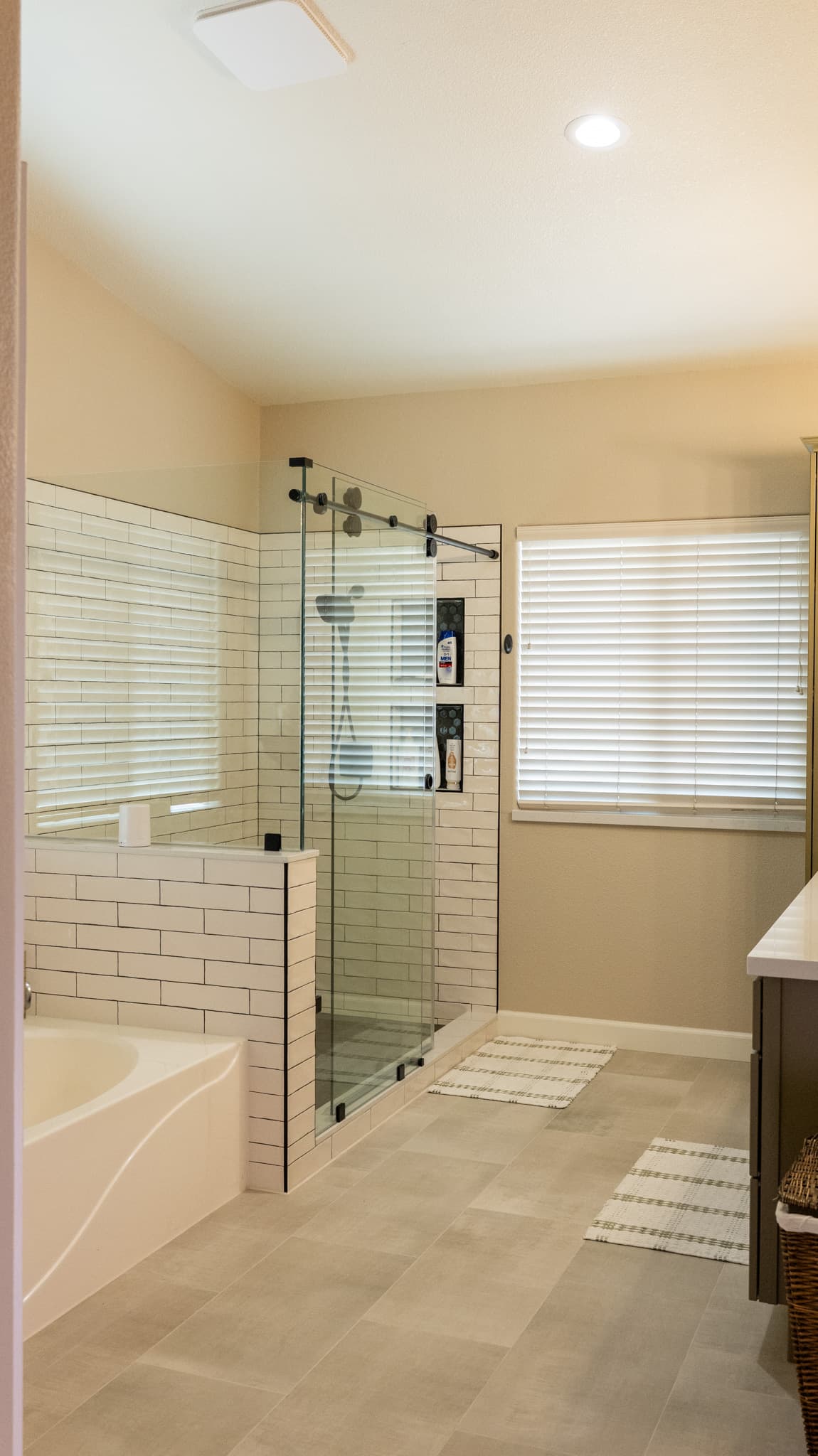 Bathroom Remodel in Sacramento — frameless glass shower, tiled shower surround, soaking tub, subway tile backsplash, porcelain tile flooring