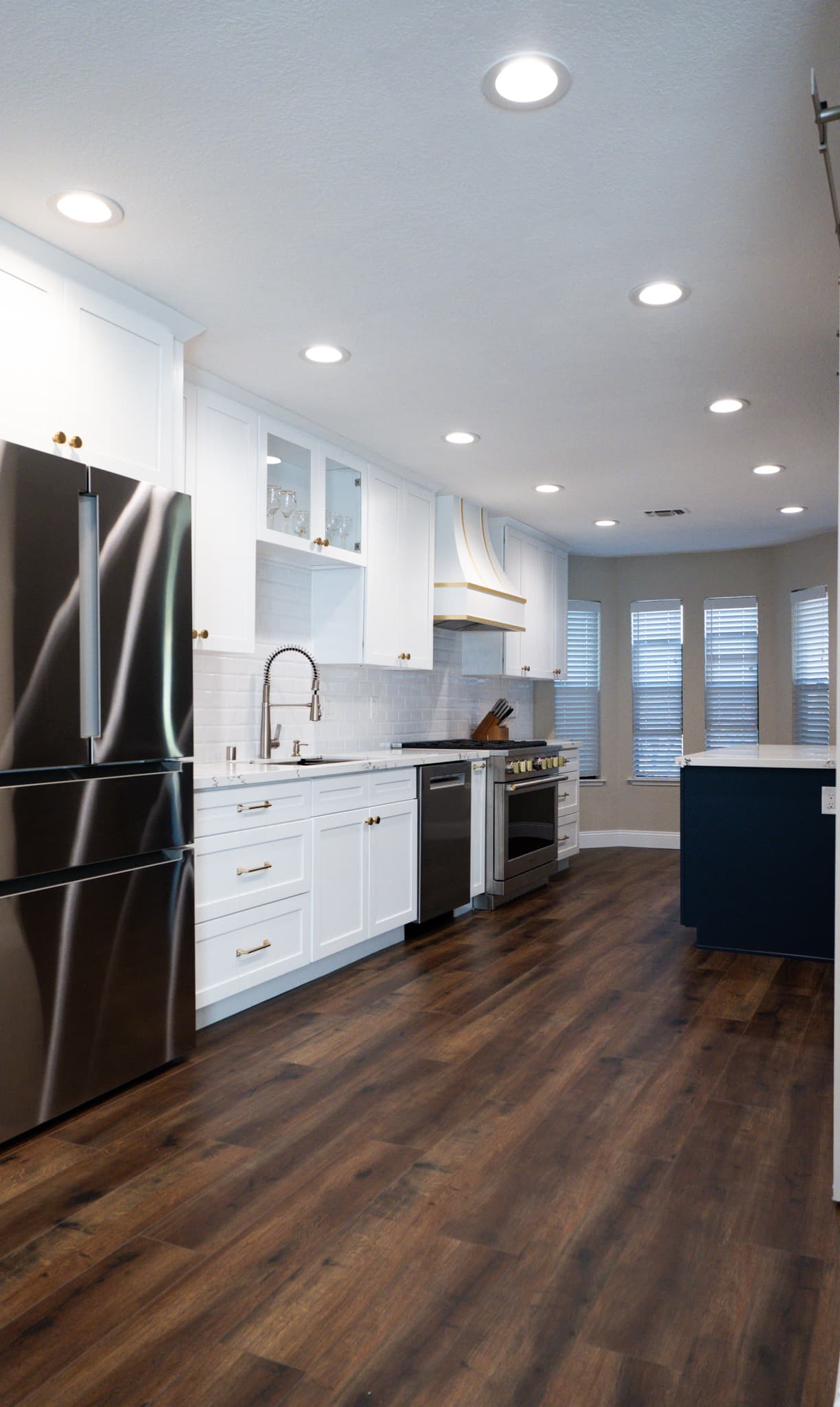 Kitchen Remodel in Roseville — shaker cabinets, two-tone cabinetry, subway tile backsplash, recessed lighting, range hood, stainless appliances, luxury vinyl plank