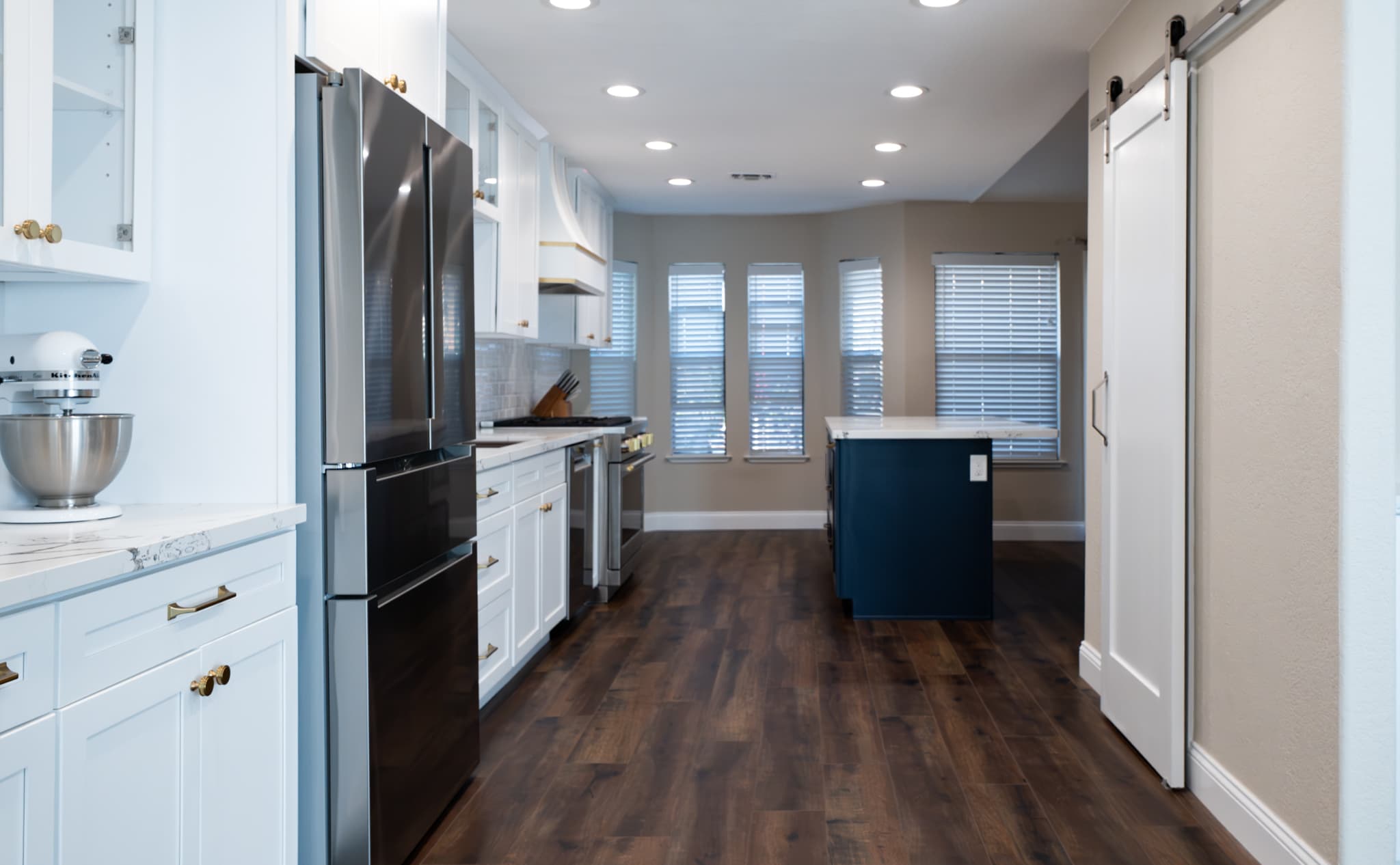 Kitchen Remodel in Roseville — two-tone cabinetry, kitchen island, recessed lighting, barn-door entry, hardwood flooring