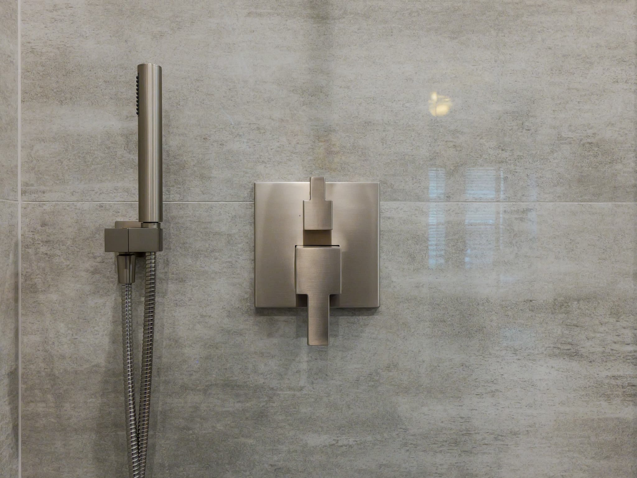 Bathroom Remodel in Roseville — tiled shower surround, handheld shower, walk-in shower, natural-stone tile flooring