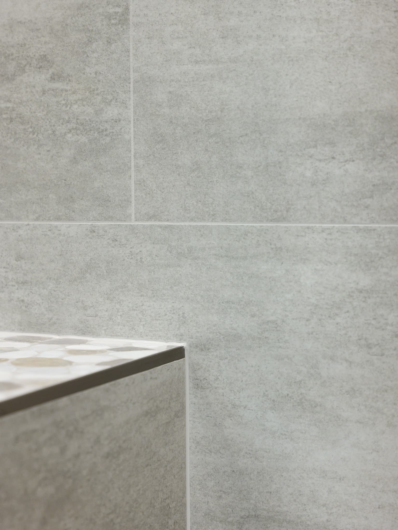 Bathroom Remodel in Roseville — tiled shower surround, shower bench, walk-in shower, mosaic backsplash, porcelain tile flooring