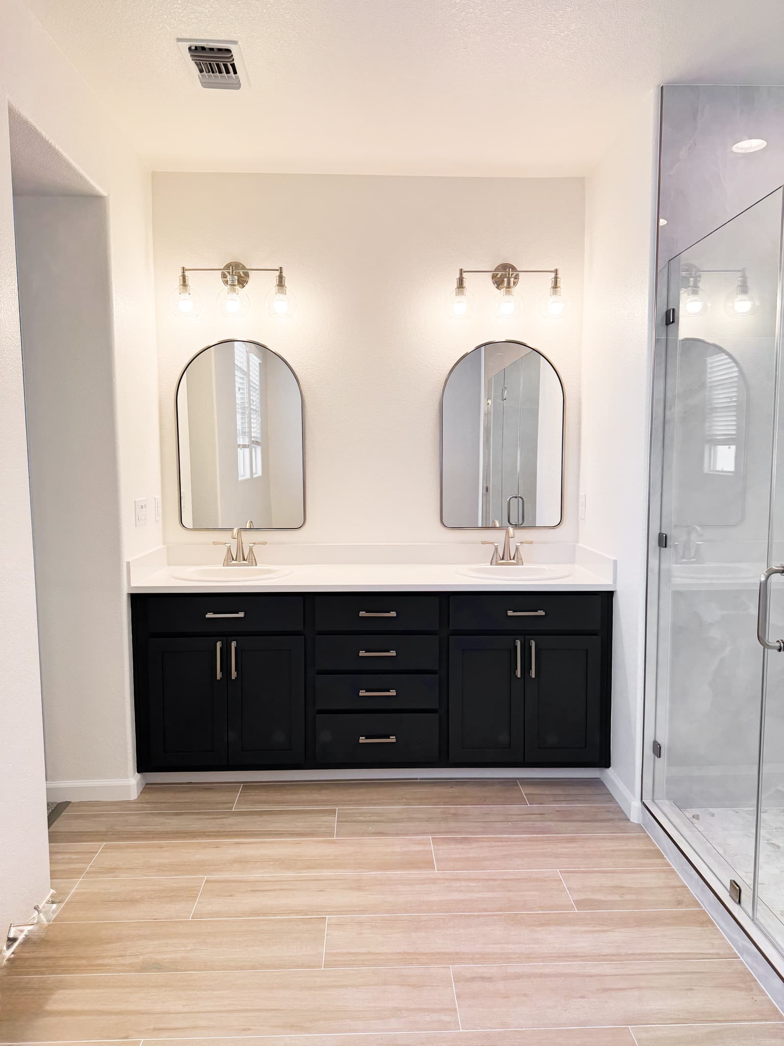 Bathroom Remodel in Sacramento — double vanity, shaker cabinets, quartz countertop, frameless glass shower, porcelain tile flooring