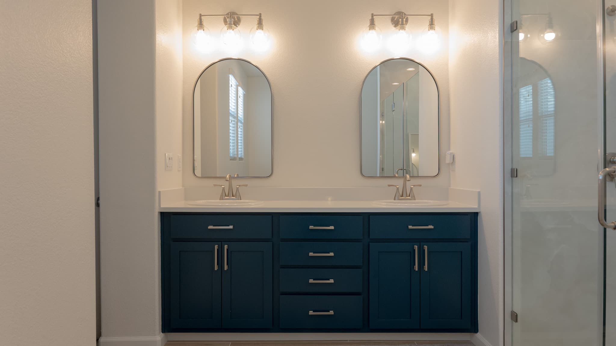 Bathroom Remodel in Sacramento — double vanity, floating vanity, shaker cabinets, framed mirror, frameless glass shower