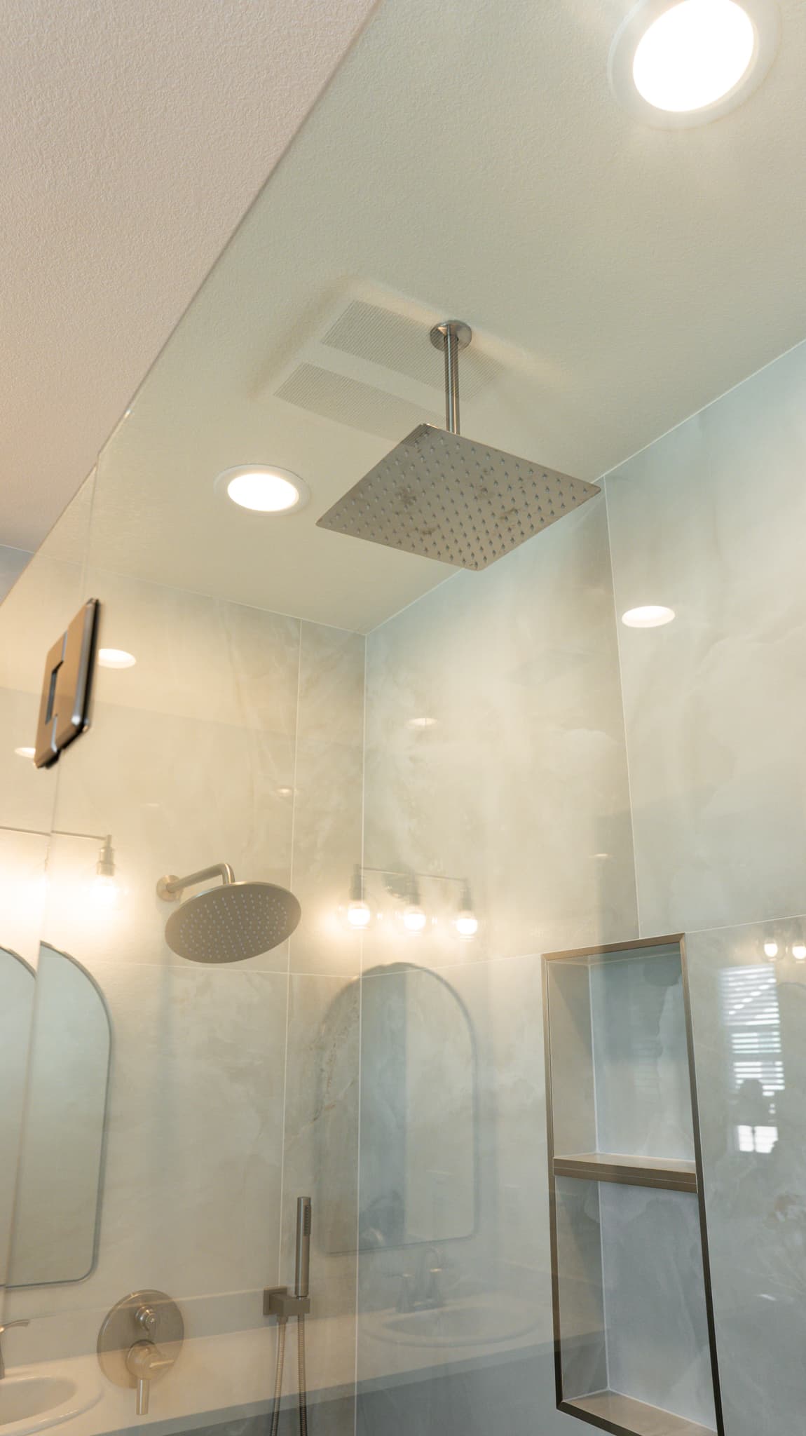 Bathroom Remodel in Sacramento — rain shower head, handheld shower, frameless glass shower, tiled shower surround, recessed lighting