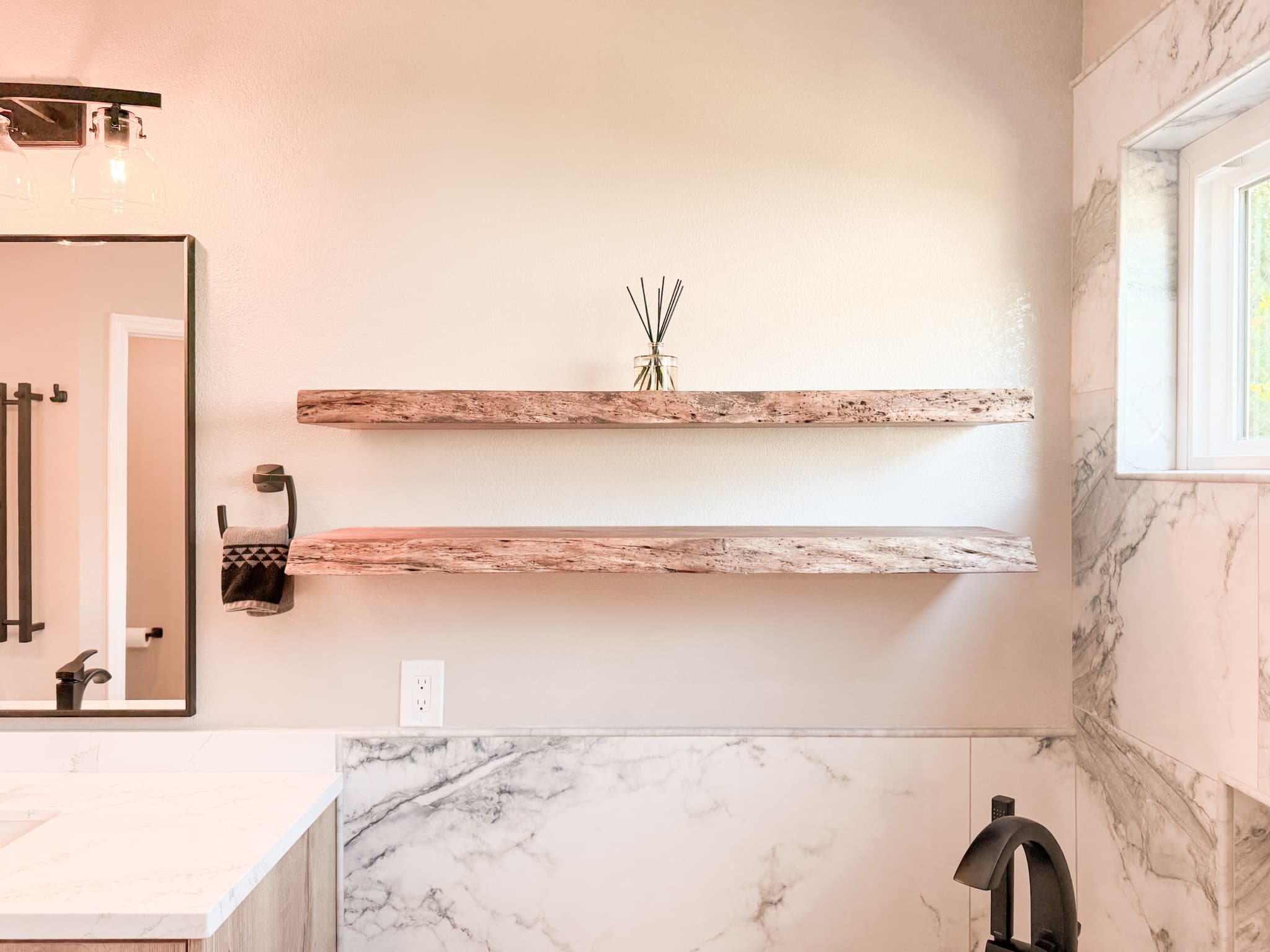 Bathroom Remodel in El Dorado Hills — built-in shelving, marble tile flooring, framed mirror, single vanity, tiled shower surround