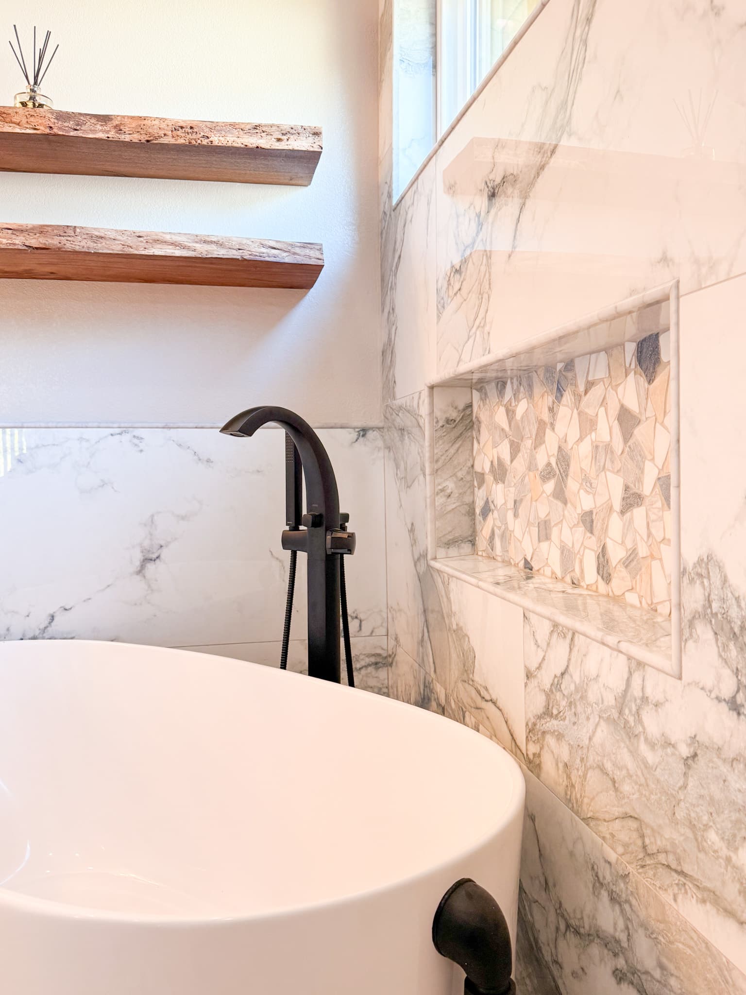 Bathroom Remodel in El Dorado Hills — freestanding tub, marble tile flooring, mosaic backsplash, handheld shower, built-in shelving