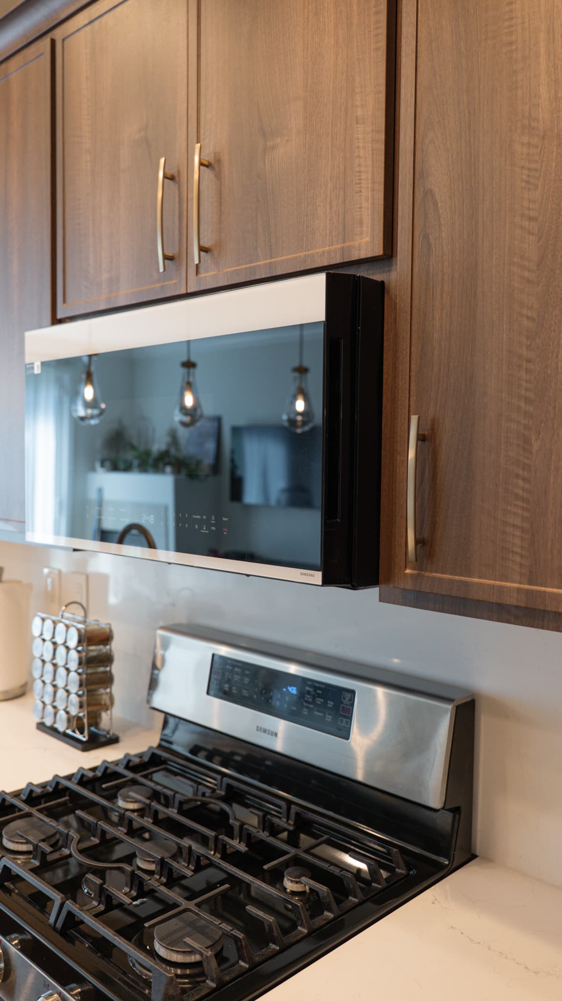 House Renovation in Roseville — raised-panel cabinets, professional gas range, stainless appliances, pendant lighting, quartz countertop