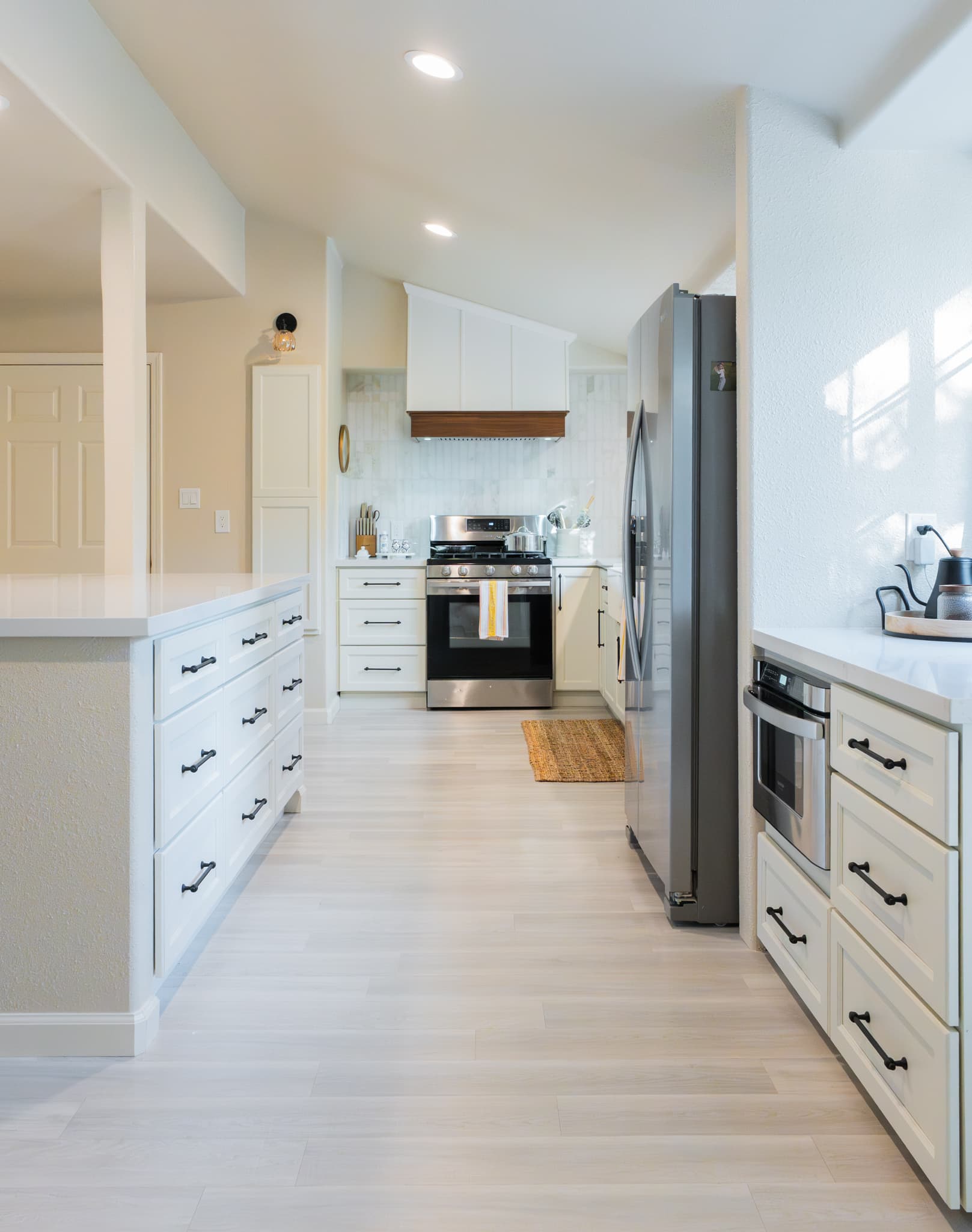 Kitchen Remodel in Rocklin — shaker cabinets, range hood, stainless appliances, recessed lighting, luxury vinyl plank