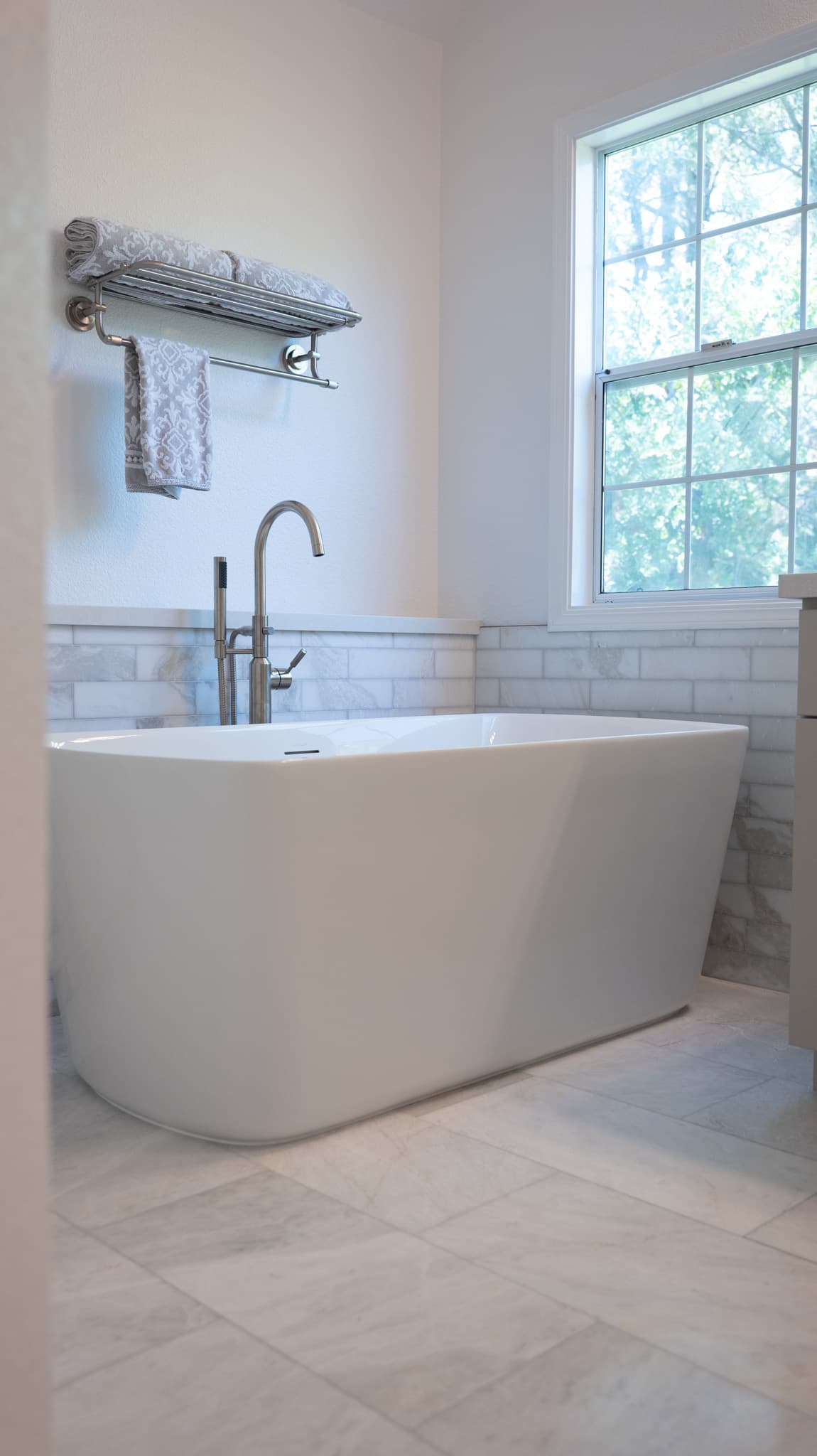 Bathroom Remodel in Sacramento — freestanding tub, soaking tub, natural-stone tile flooring, natural-stone backsplash, handheld shower