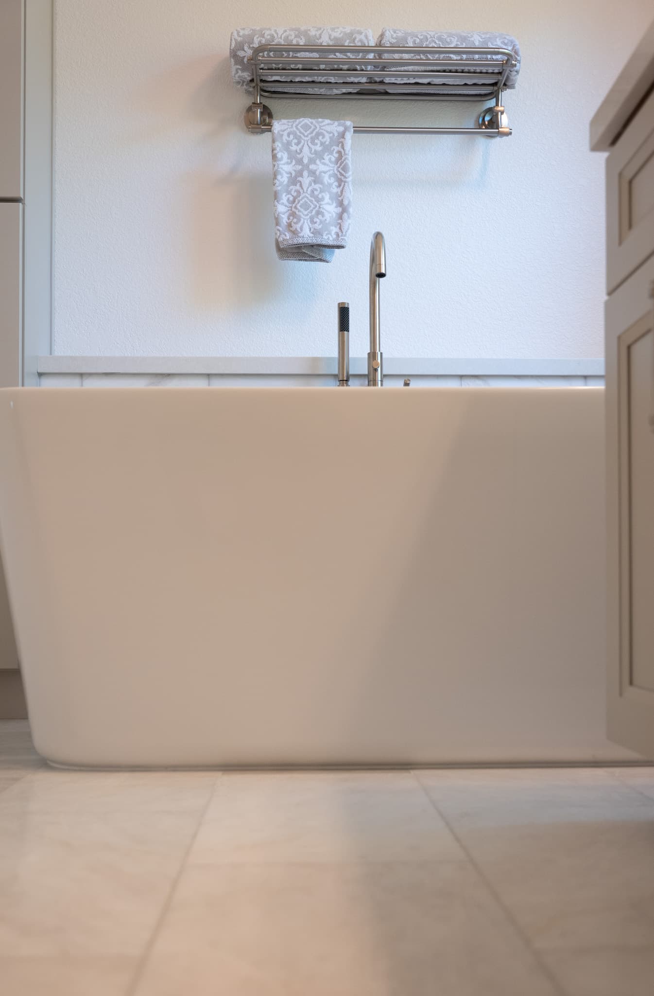 Bathroom Remodel in Sacramento — freestanding tub, soaking tub, handheld shower, marble tile flooring, raised-panel cabinets