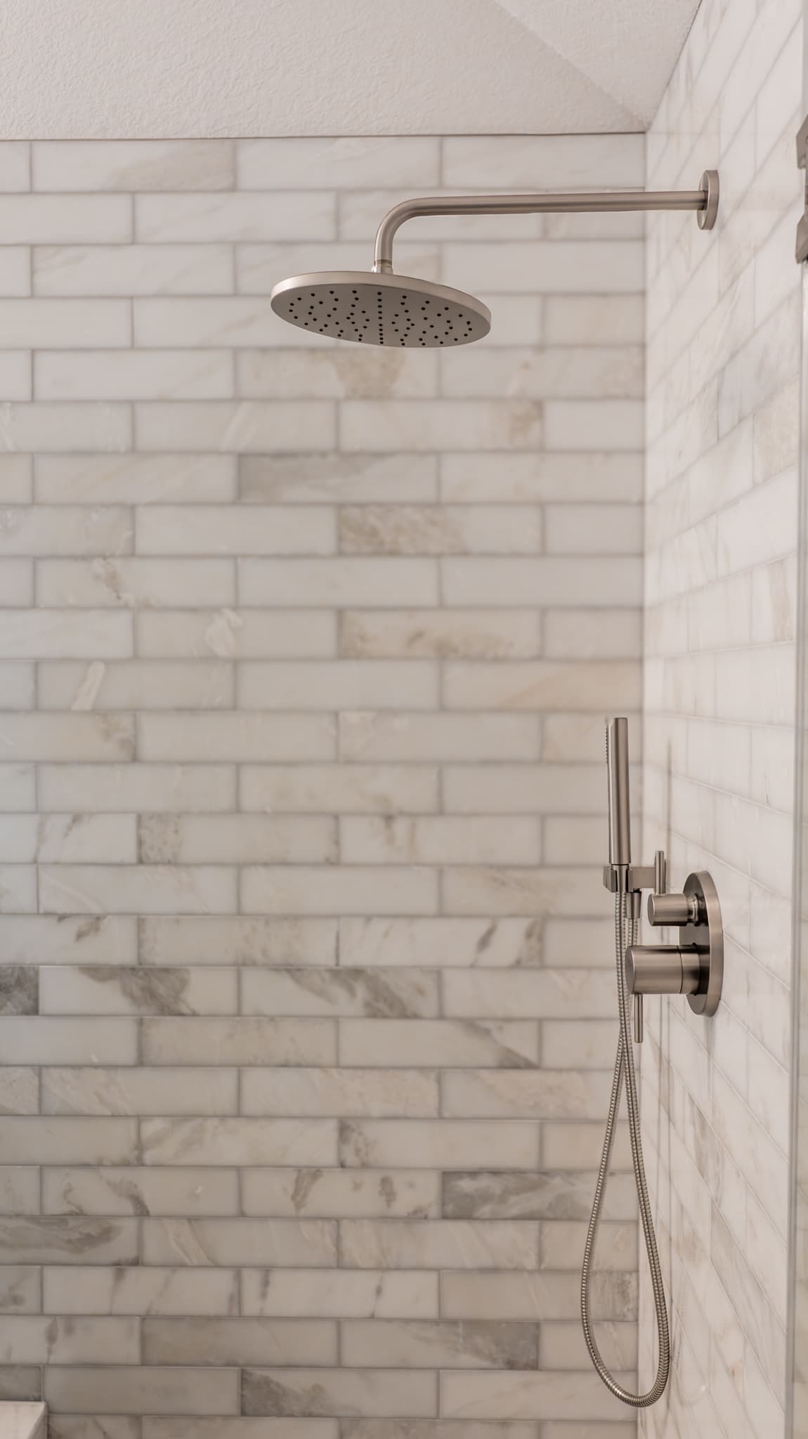 Bathroom Remodel in Sacramento — tiled shower surround, rain shower head, handheld shower, walk-in shower, natural-stone backsplash