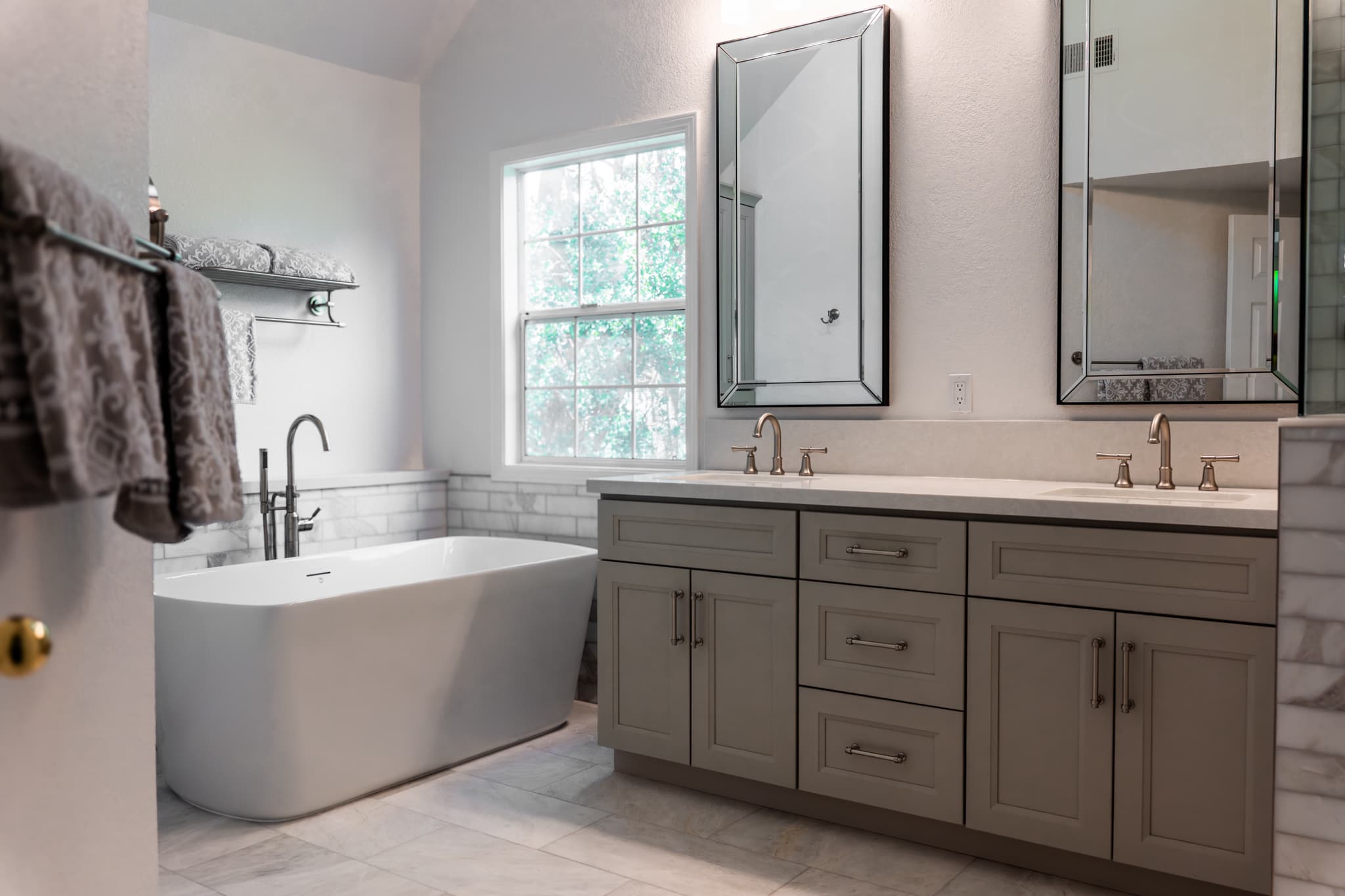 Bathroom Remodel in Sacramento — freestanding tub, double vanity, shaker cabinets, framed mirror, marble tile flooring