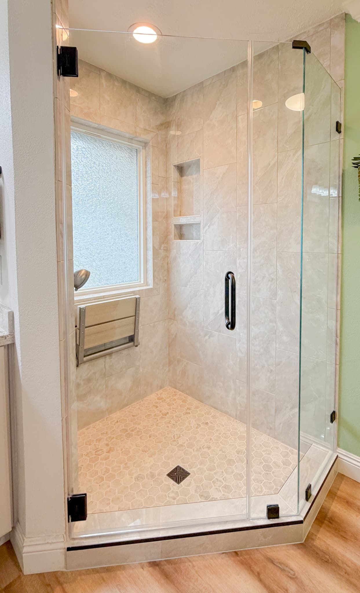 Bathroom Remodel in Sacramento — frameless glass shower, walk-in shower, tiled shower surround, shower bench, luxury vinyl plank