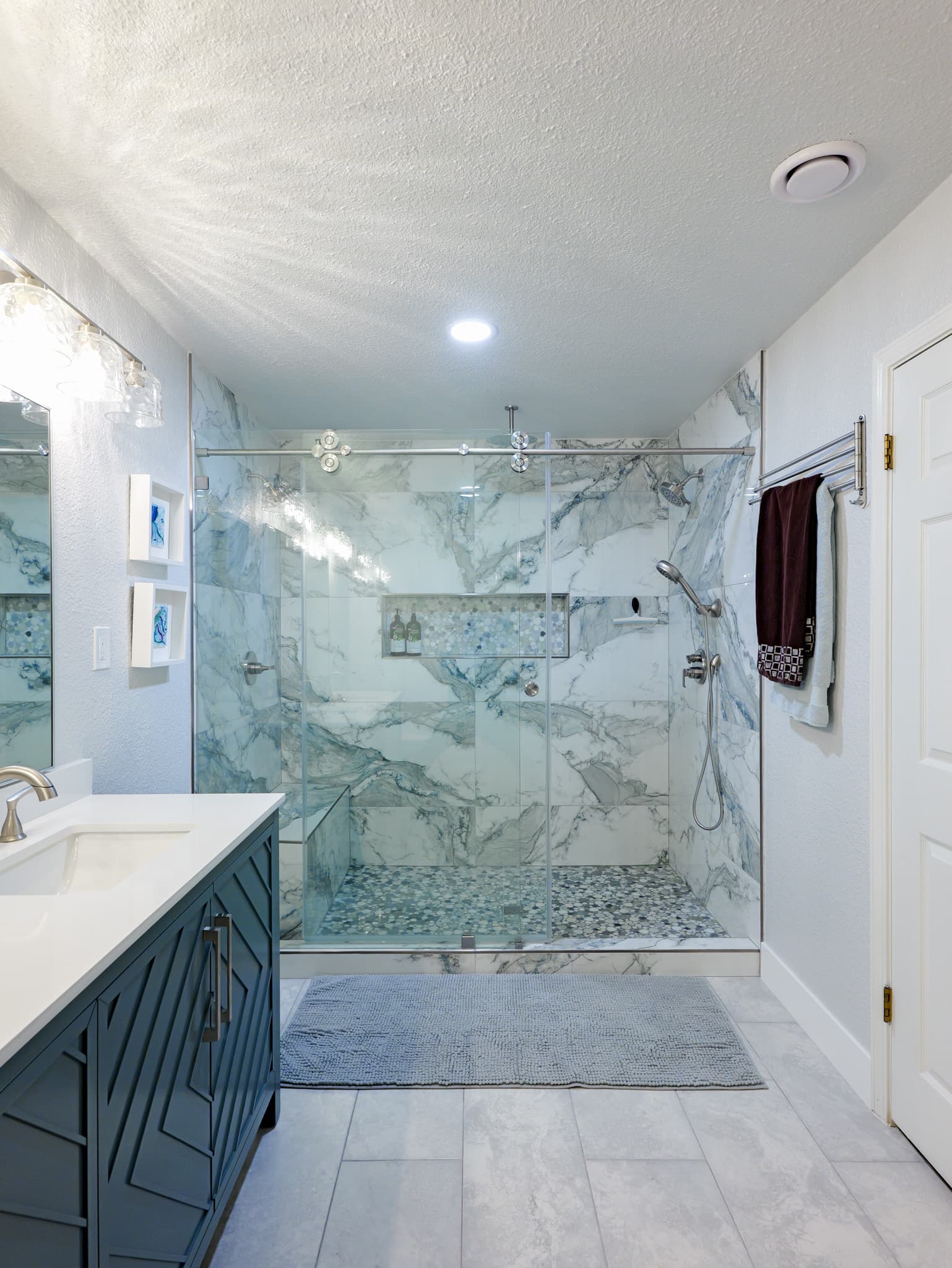 Bathroom Remodel in Sacramento — frameless glass shower, tiled shower surround, handheld shower, single vanity, porcelain tile flooring