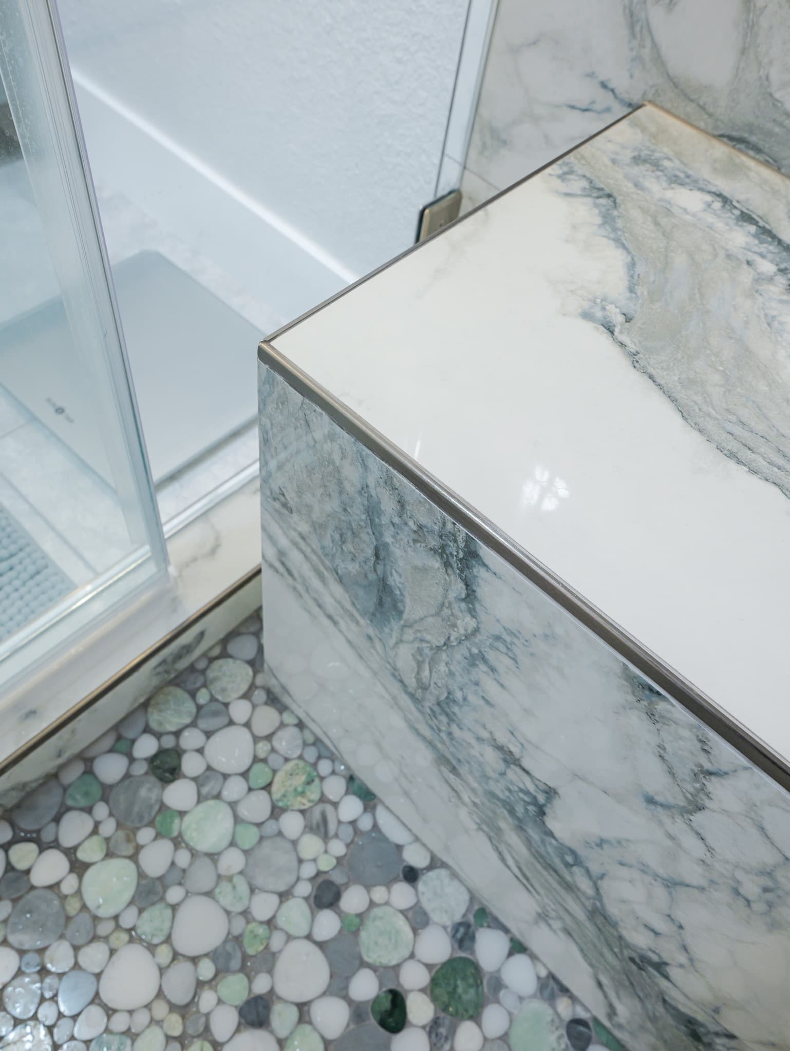Bathroom Remodel in Sacramento — marble tile flooring, shower bench, frameless glass shower, tiled shower surround, mosaic backsplash