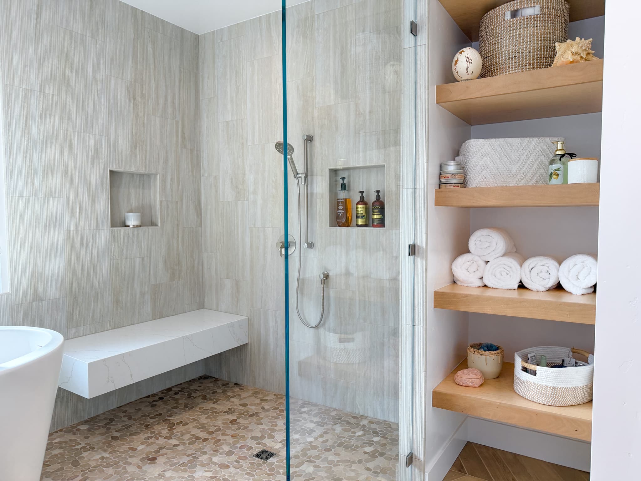 Bathroom Remodel in Carmichael — frameless glass shower, tiled shower surround, shower bench, handheld shower, built-in shelving