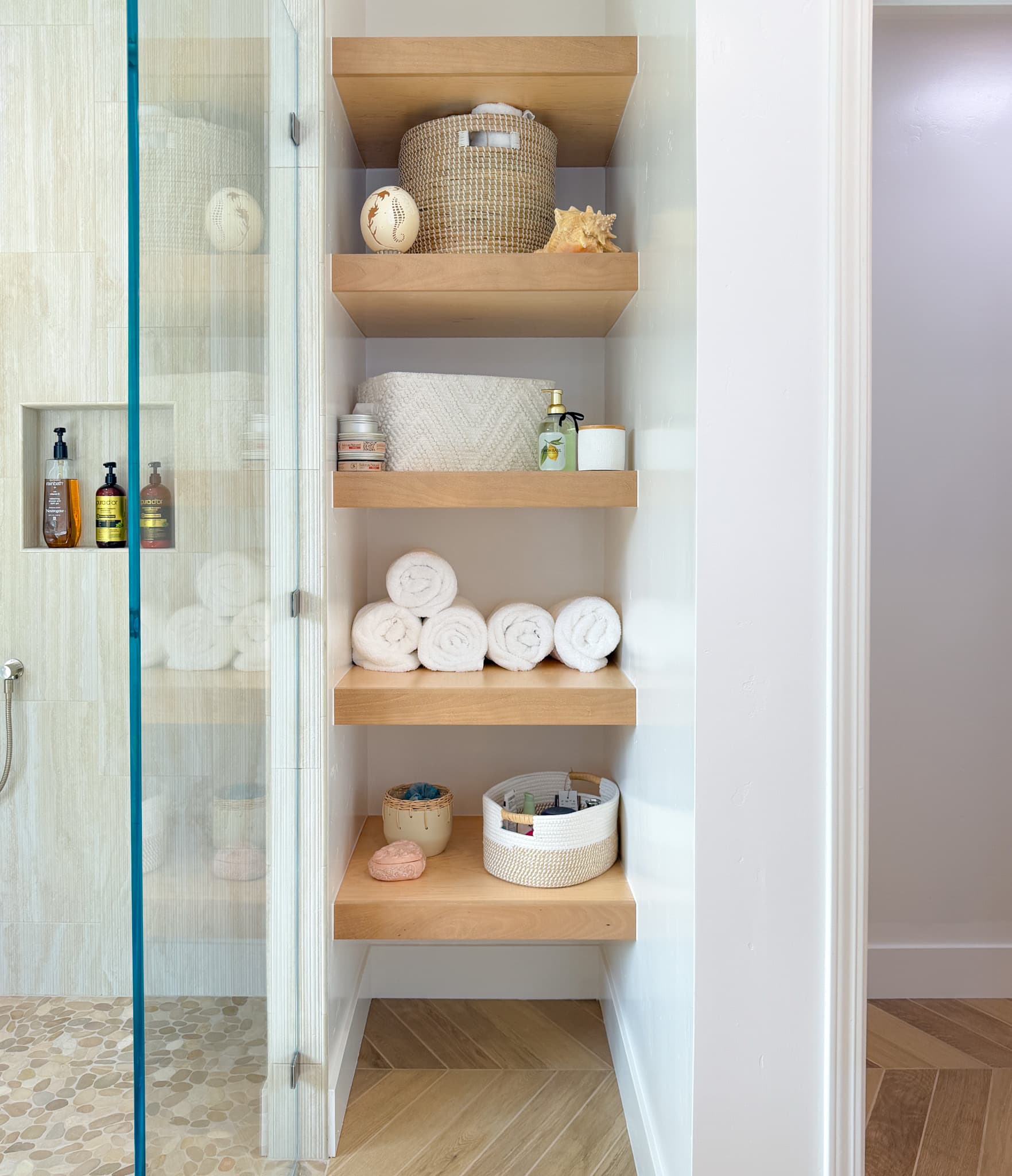 Bathroom Remodel in Carmichael — built-in shelving, frameless glass shower, tiled shower surround, natural-stone tile flooring, hardwood flooring