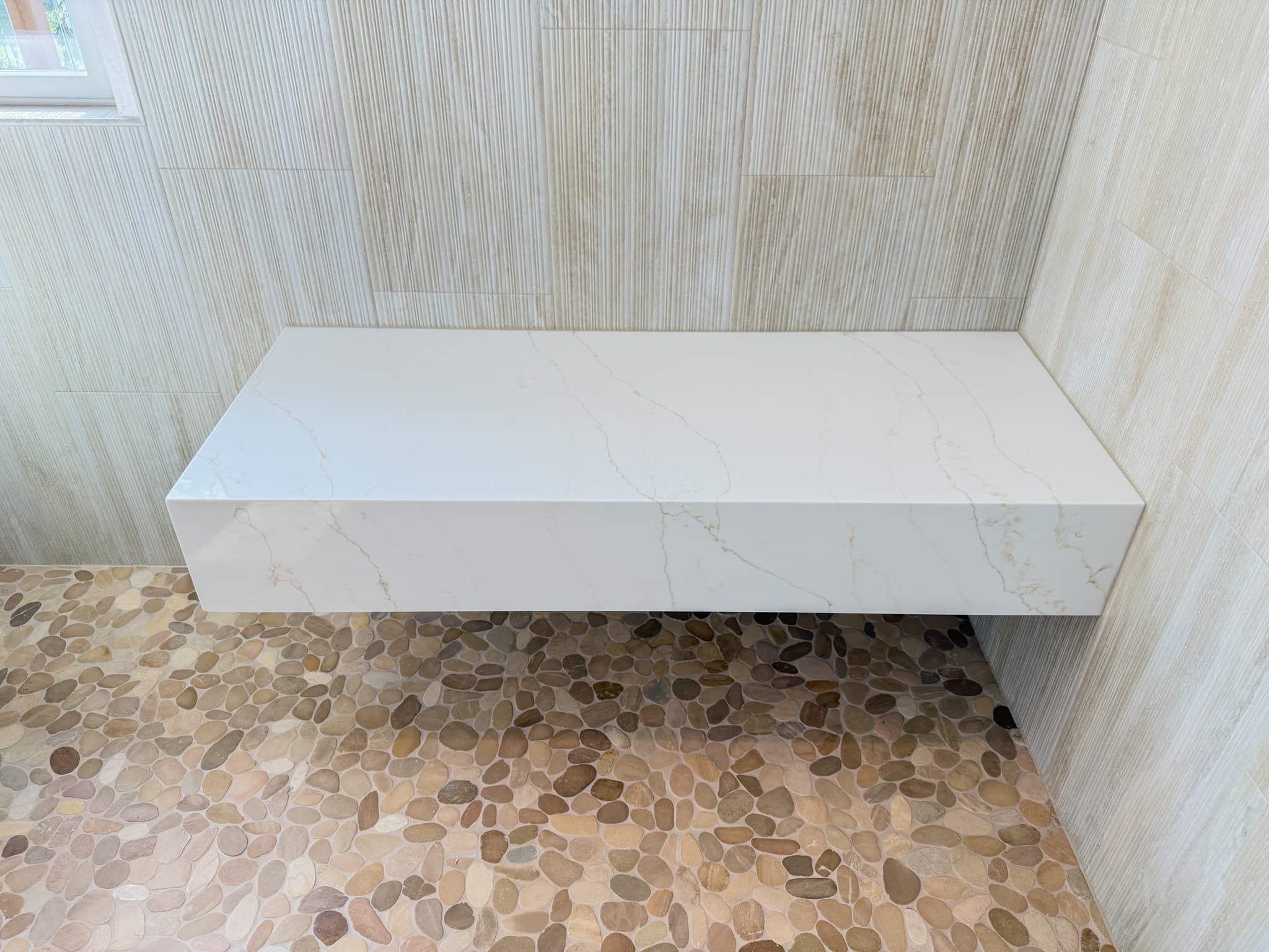 Bathroom Remodel in Carmichael — shower bench, quartz countertop, tiled shower surround, natural-stone tile flooring, walk-in shower
