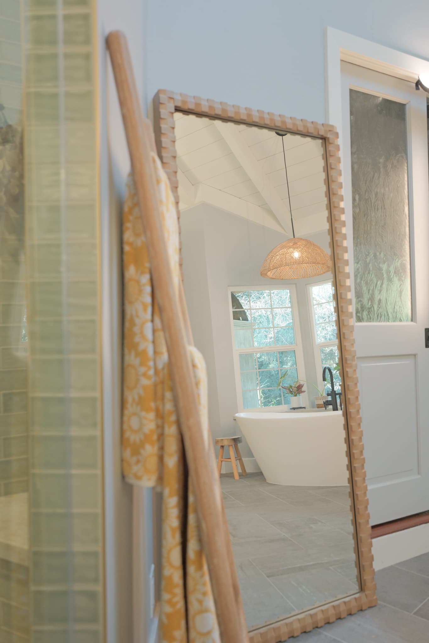 House Renovation in Sacramento — freestanding tub, pendant lighting, tiled shower surround, framed mirror, natural-stone tile flooring