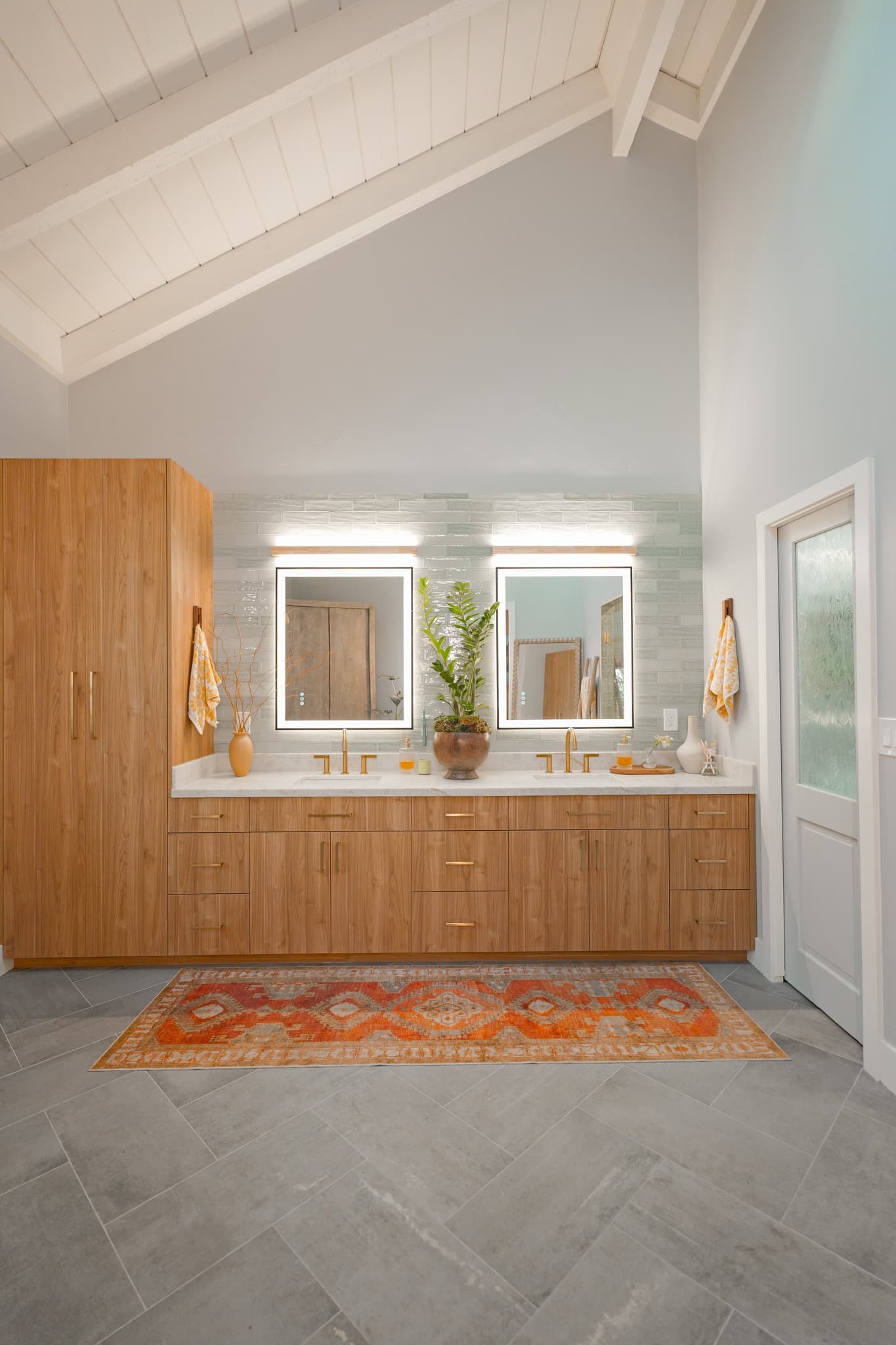 House Renovation in Sacramento — double vanity, floating vanity, lighted mirror, vaulted ceiling, natural-stone tile flooring