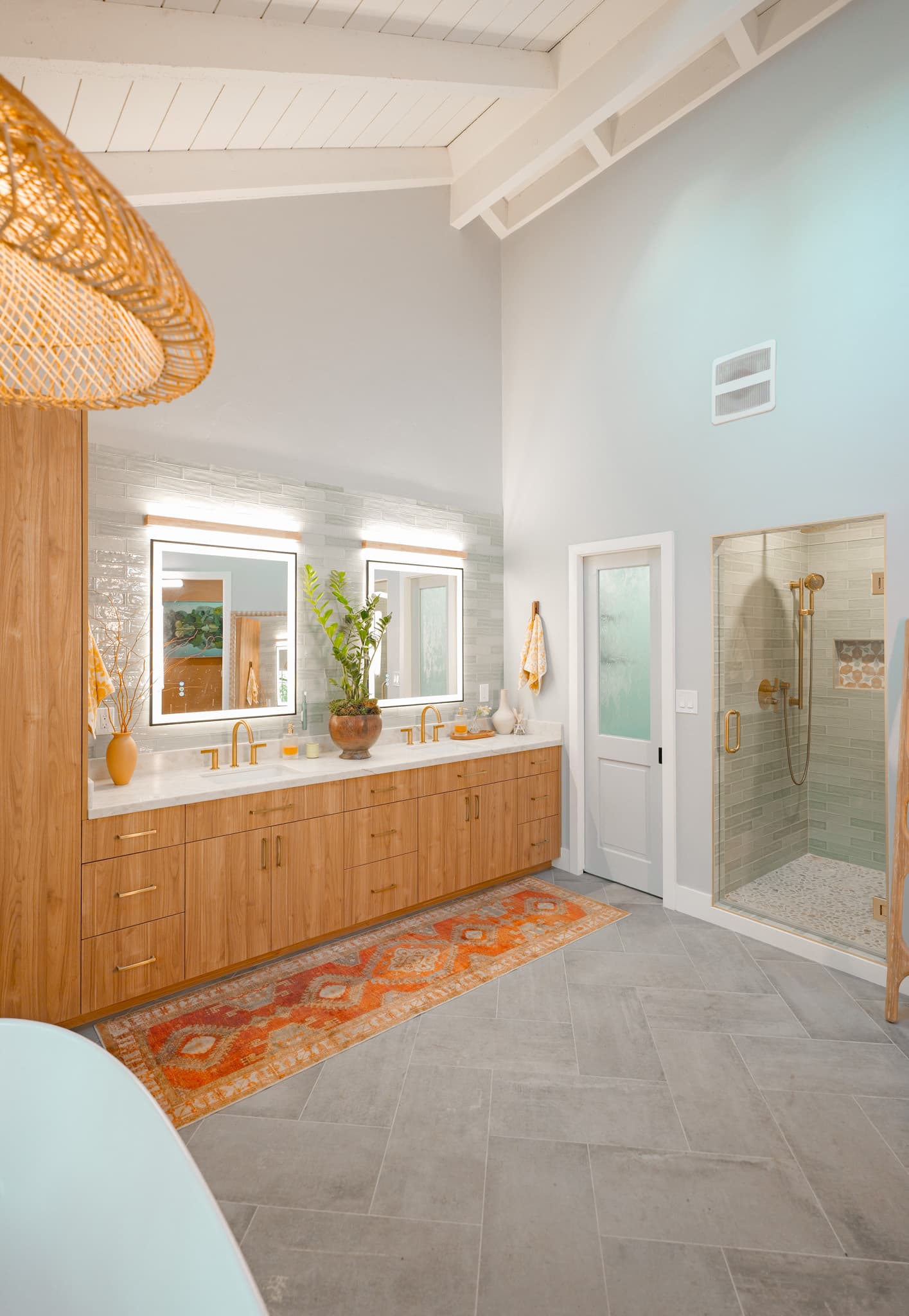 House Renovation in Sacramento — double vanity, lighted mirror, frameless glass shower, tiled shower surround, vaulted ceiling