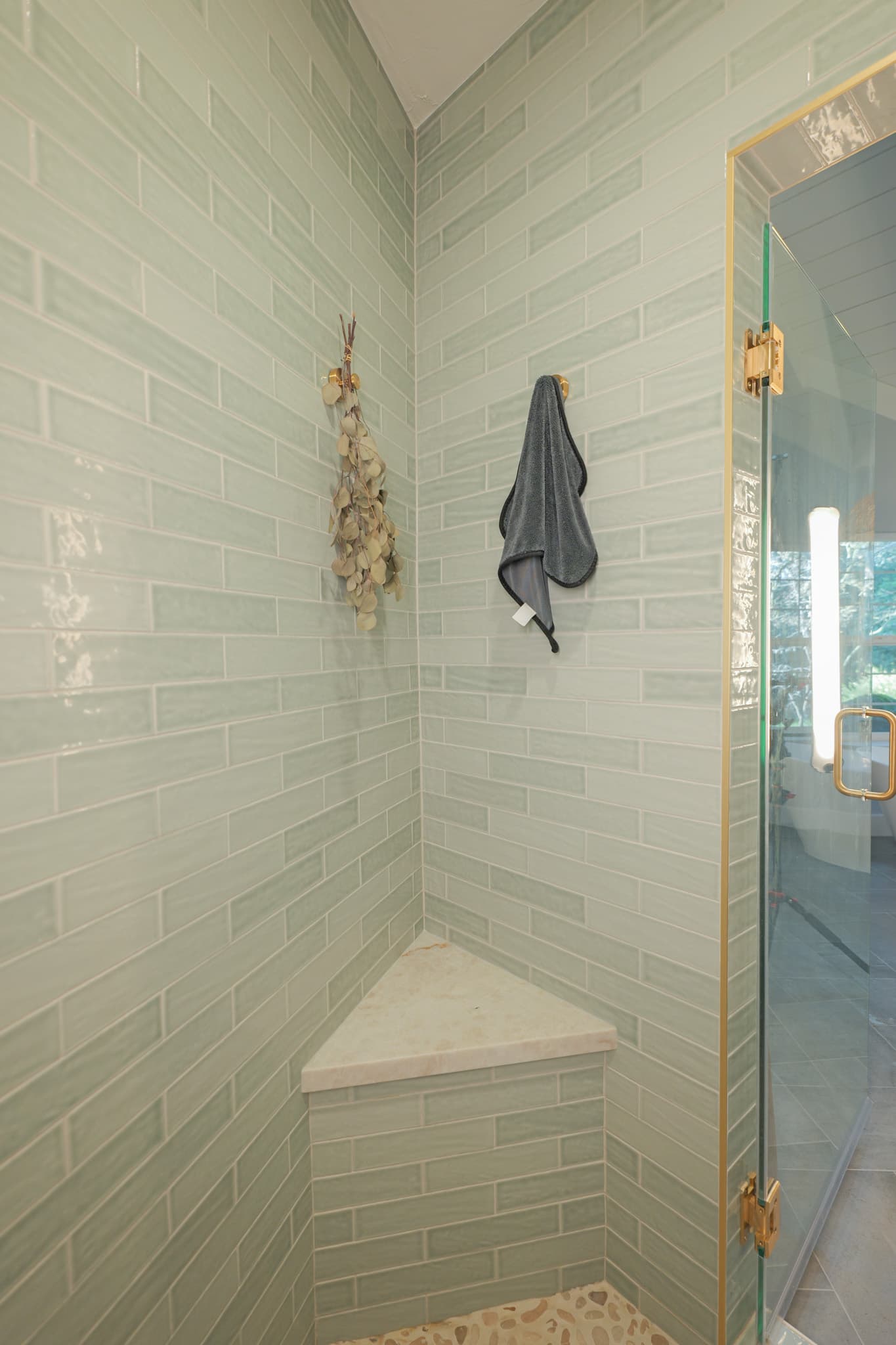 House Renovation in Sacramento — walk-in shower, tiled shower surround, frameless glass shower, shower bench, natural-stone tile flooring