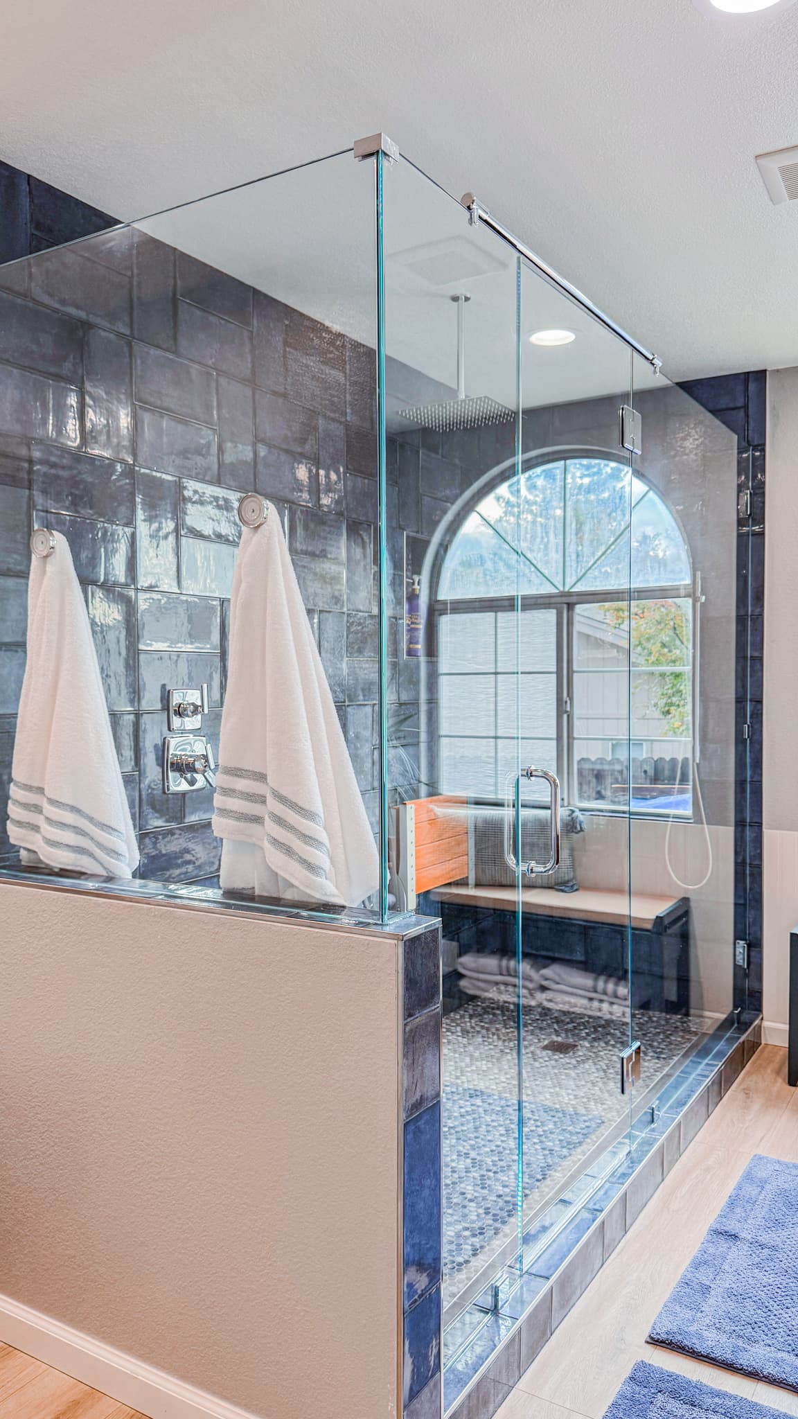 Bathroom Remodel in Sacramento — frameless glass shower, tiled shower surround, shower bench, handheld shower, rain shower head