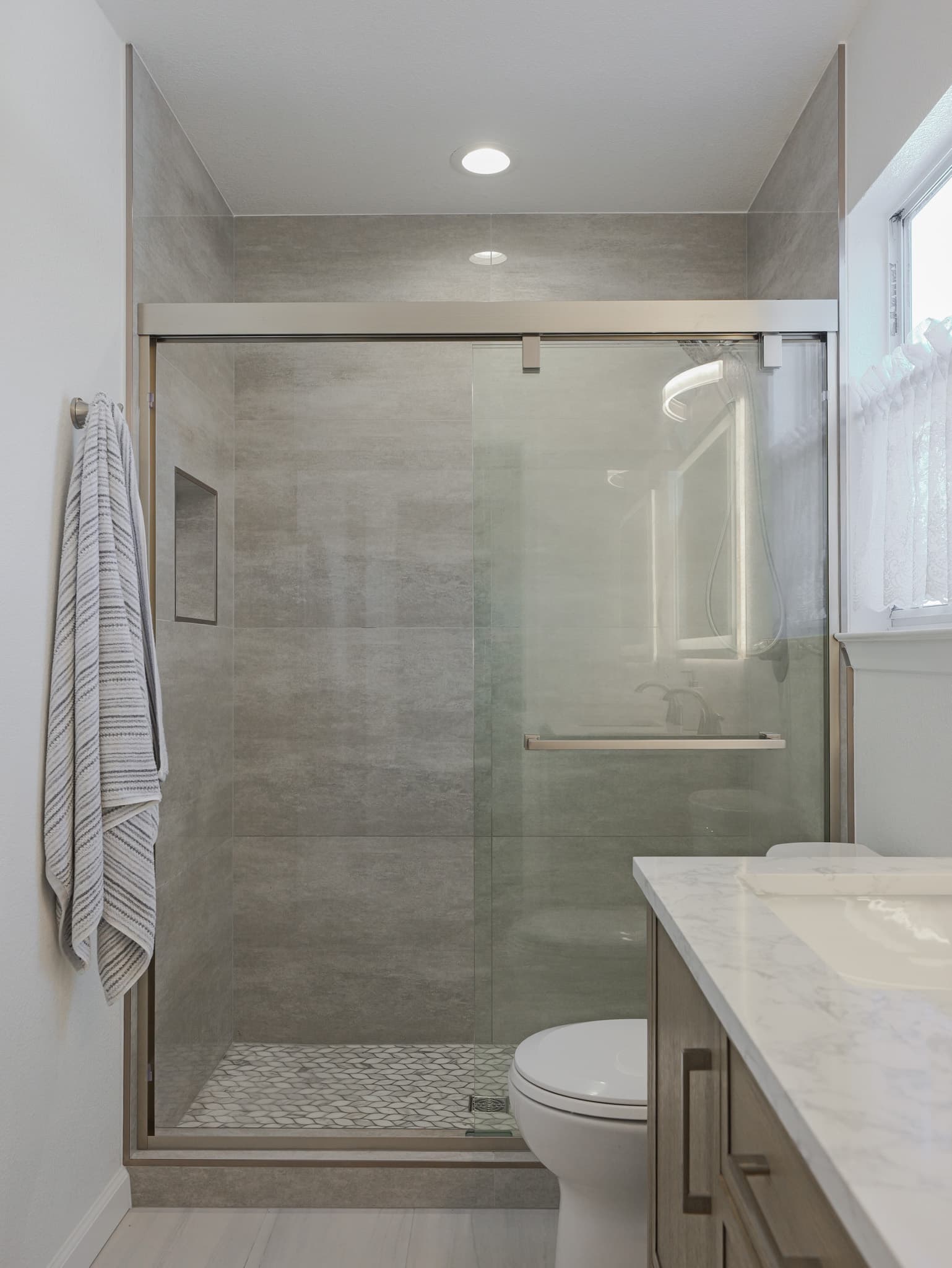 Bathroom Remodel in Sacramento — walk-in shower, tiled shower surround, mosaic backsplash, recessed lighting, single vanity