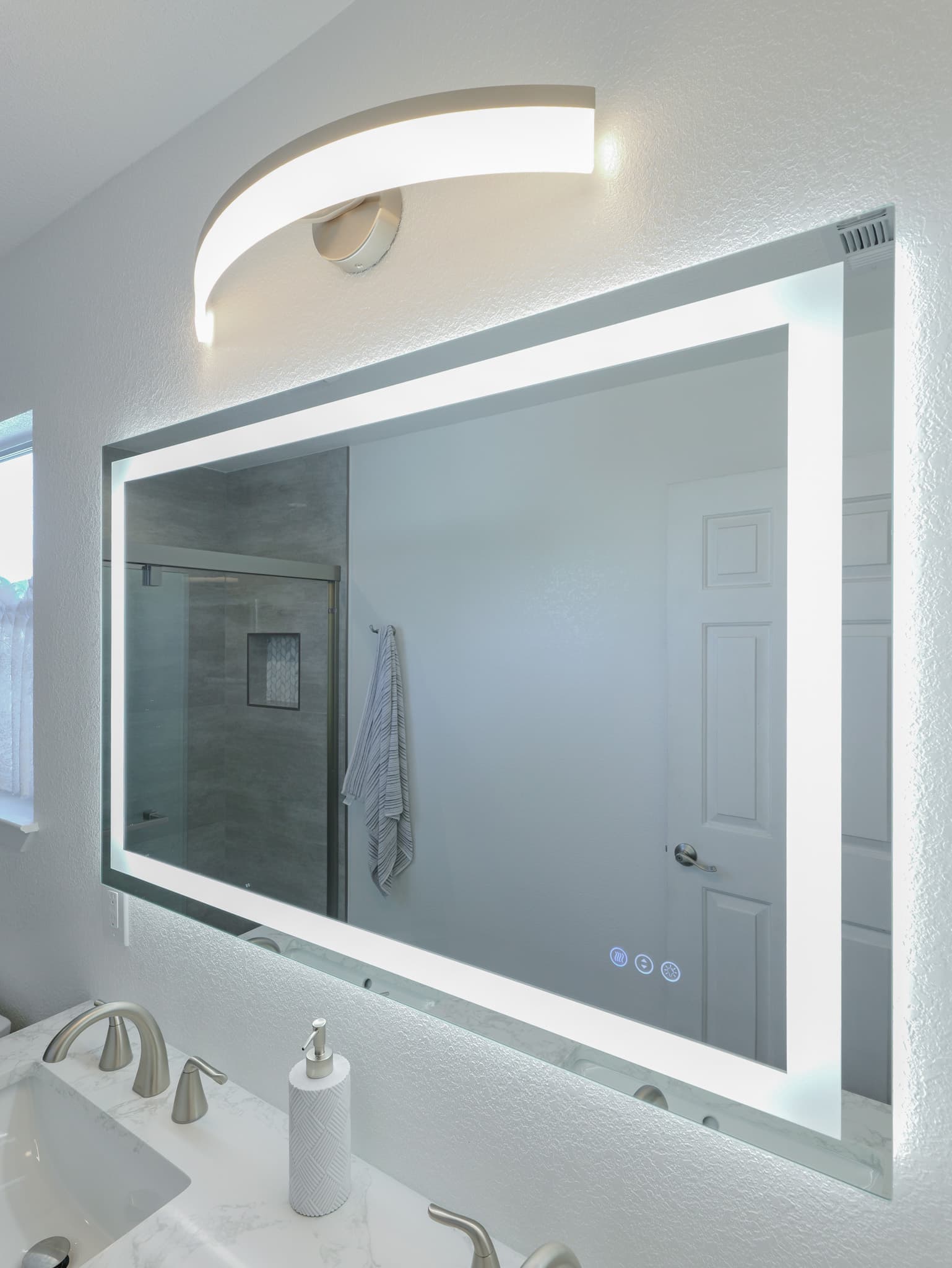 Bathroom Remodel in Sacramento — lighted mirror, double vanity, undermount sink, marble countertop, frameless glass shower
