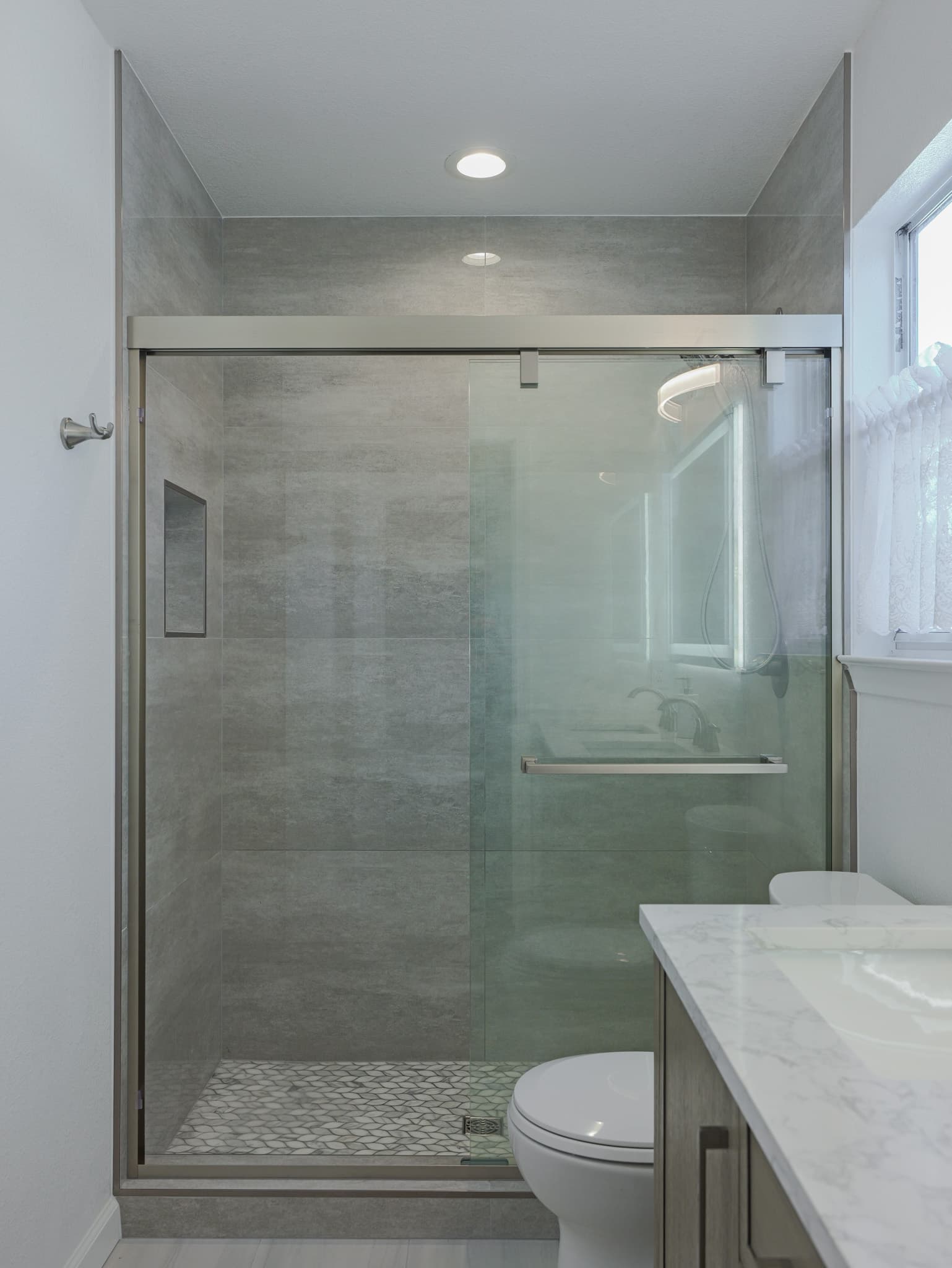 Bathroom Remodel in Sacramento — walk-in shower, frameless glass shower, tiled shower surround, recessed lighting, mosaic backsplash