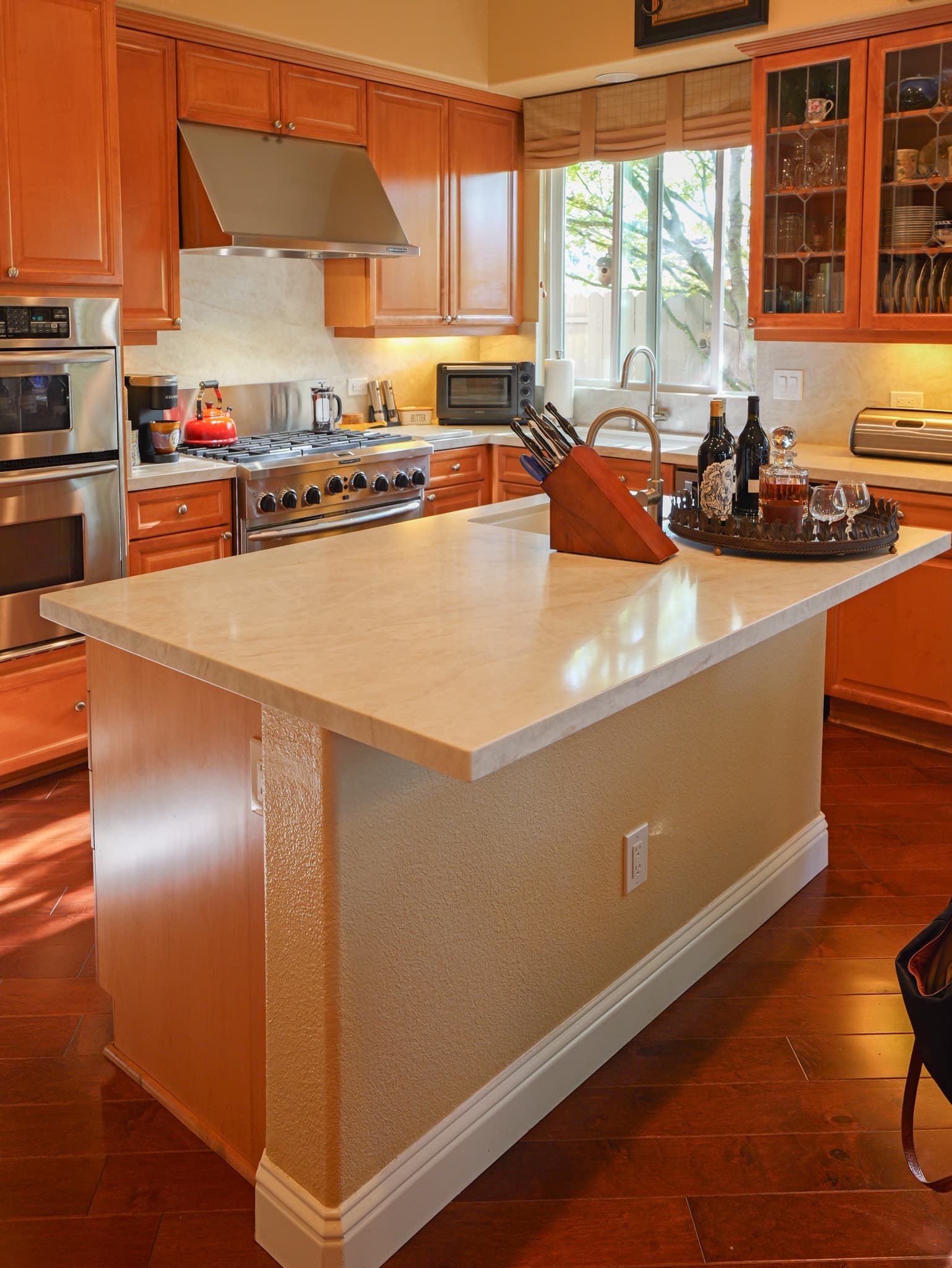 Kitchen Remodel in Roseville — raised-panel cabinets, kitchen island, range hood, professional gas range, hardwood flooring