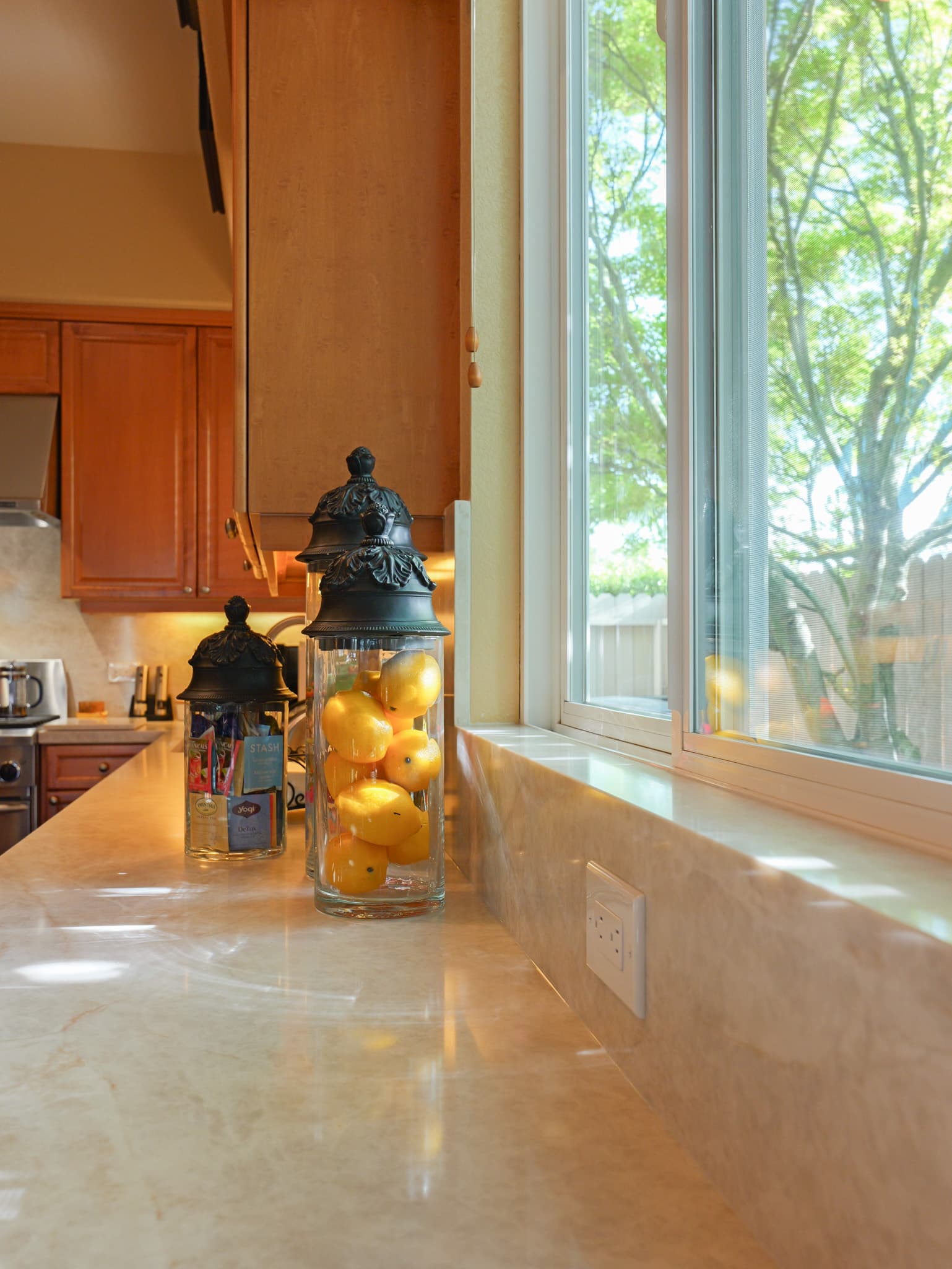 Kitchen Remodel in Roseville — marble countertop, raised-panel cabinets, under-cabinet lighting, natural-stone backsplash, vaulted ceiling